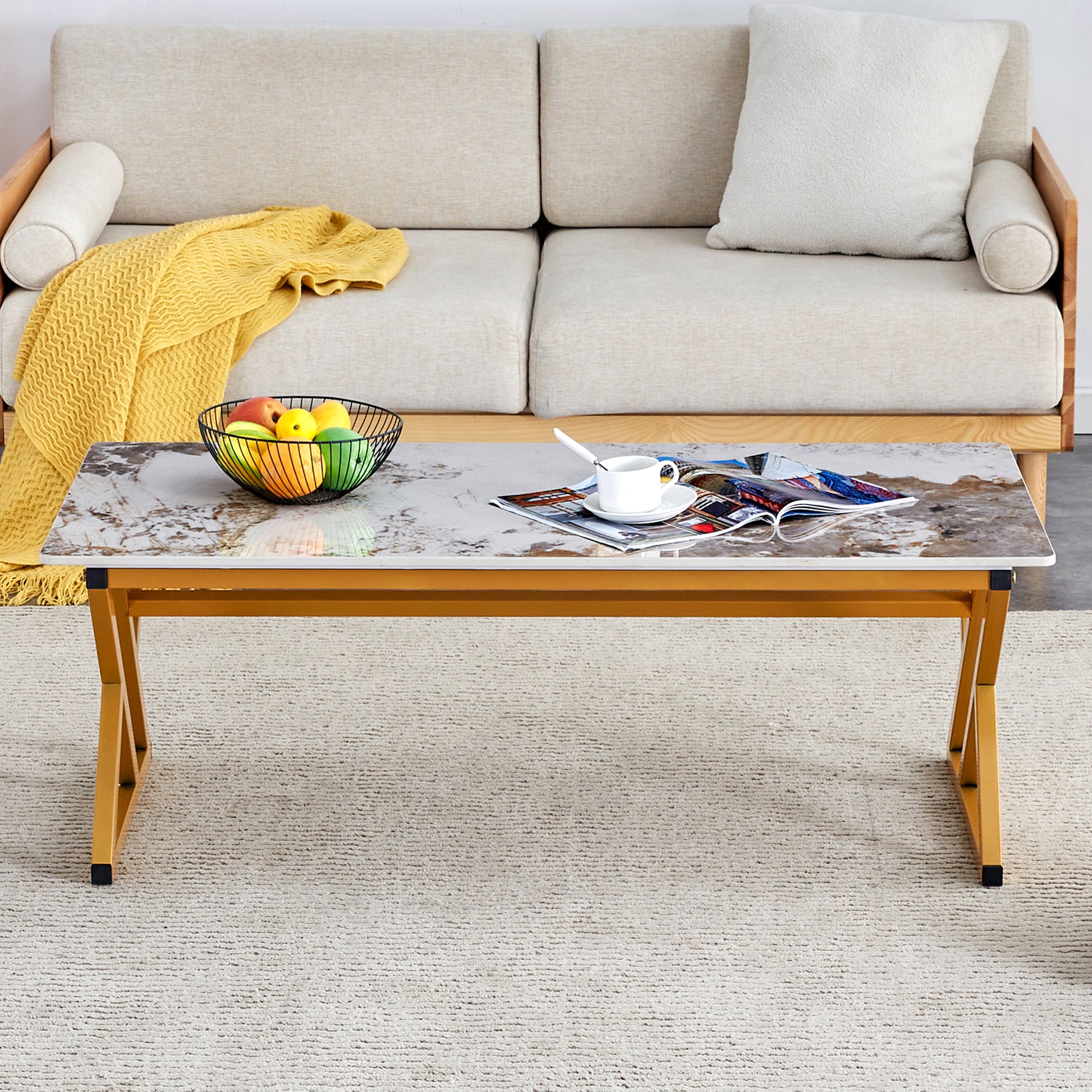 Marble top laptop desk with gold metal legs featuring a fruit bowl and magazine