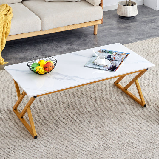 Marblelook folding coffee table with gold geometric legs on a textured rug