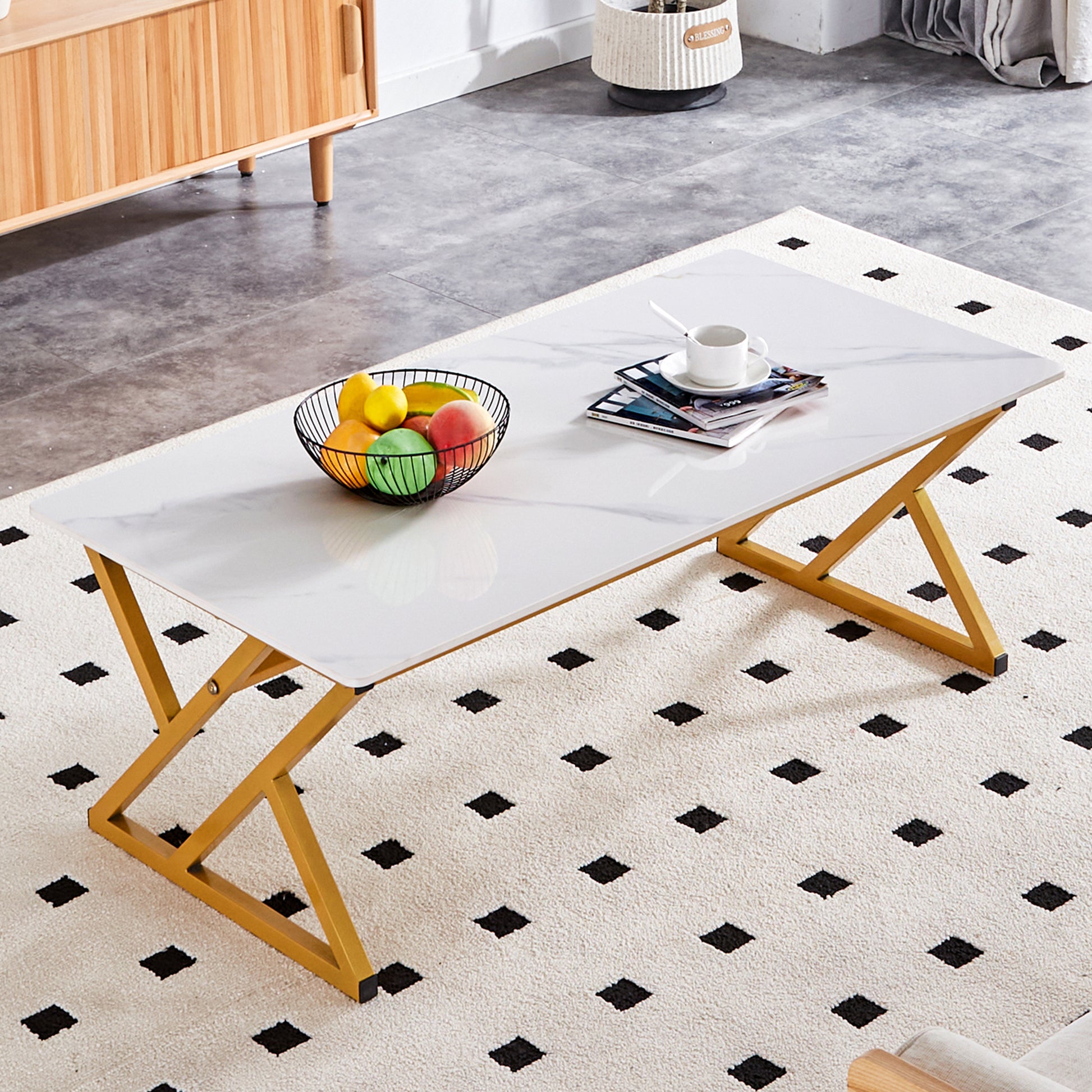Marble top coffee table with gold metal base and fruit bowl on top