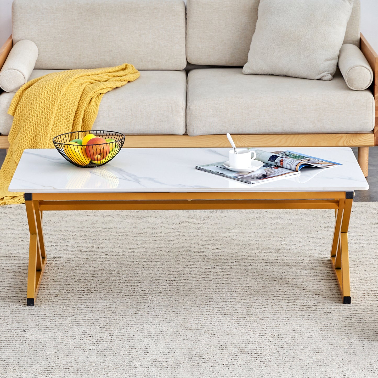 White marble top coffee table with gold metal legs placed on a rug