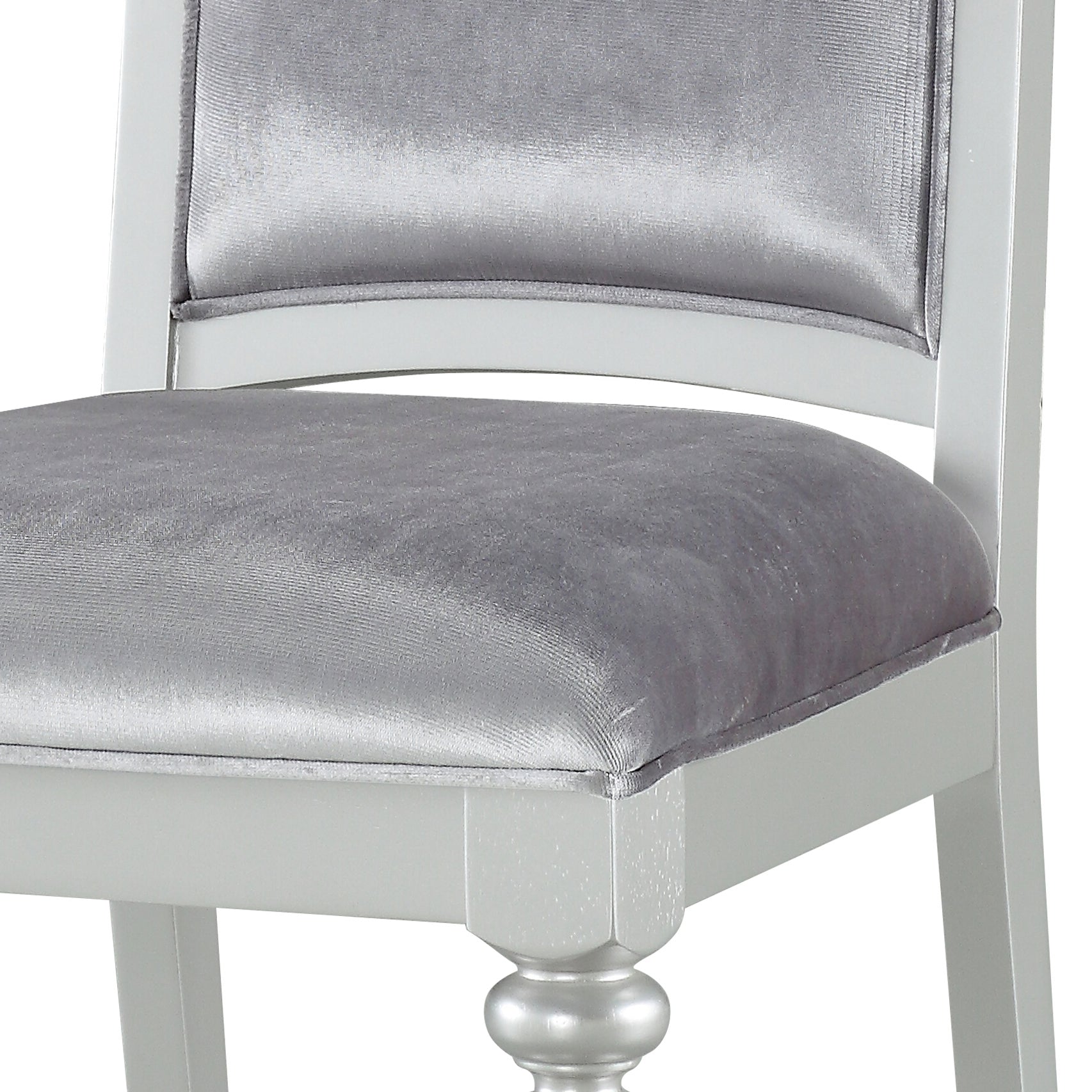 Silver velvet upholstered dining chair with white wooden frame and ornate leg