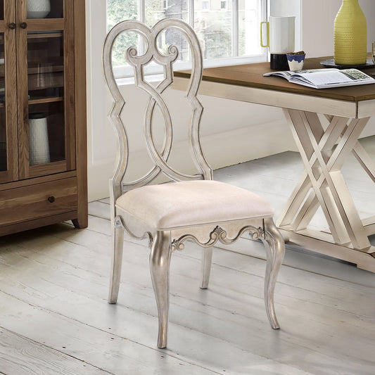 Ornate silver upholstered dining chair with scrolled back and carved legs for elegant seating