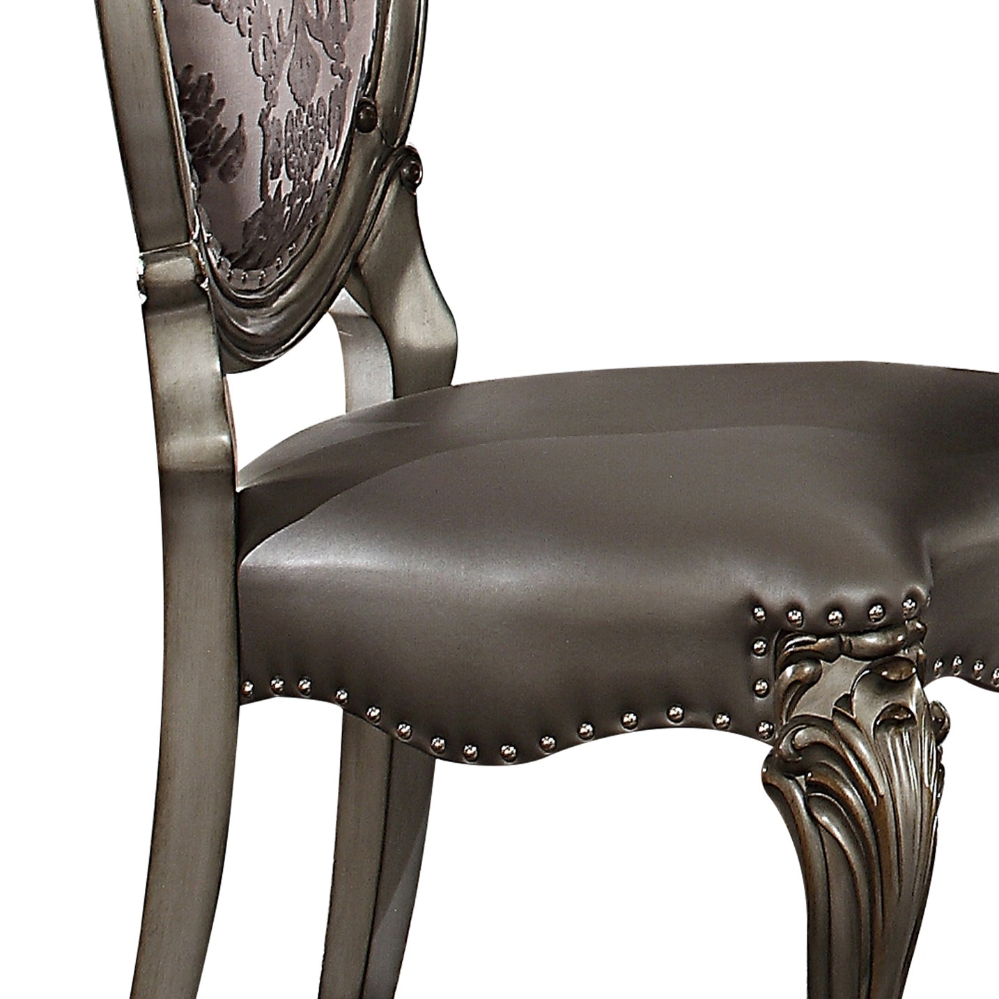 Ornate dining chair with dark brown faux leather seat and carved leg