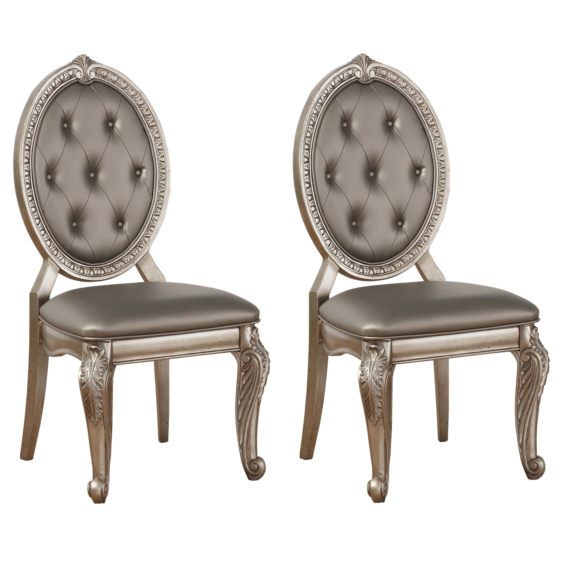 Two ornate silver dining chairs with tufted grey seats and carved legs