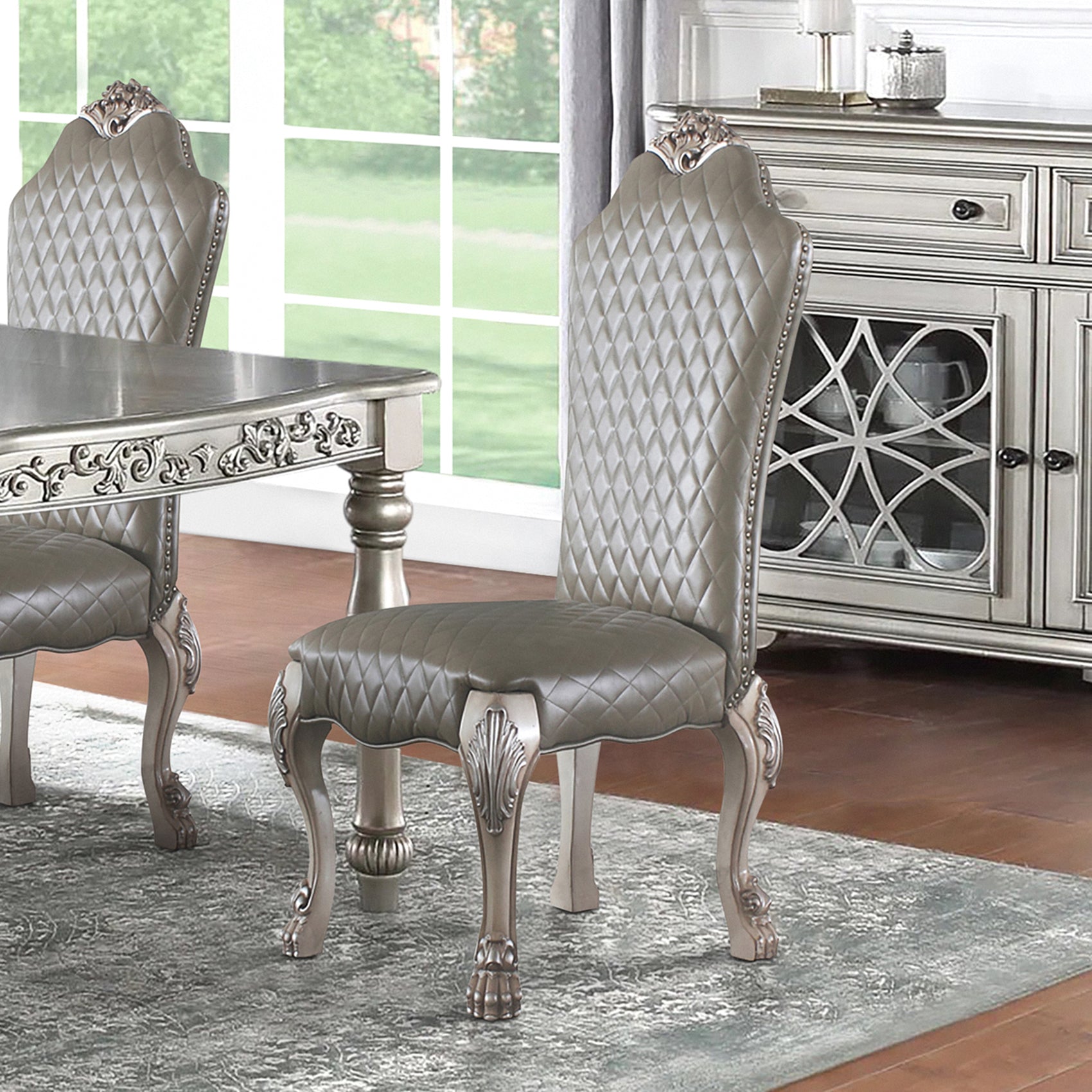 Quilted grey faux leather dining chair with ornate carved legs and silver trim