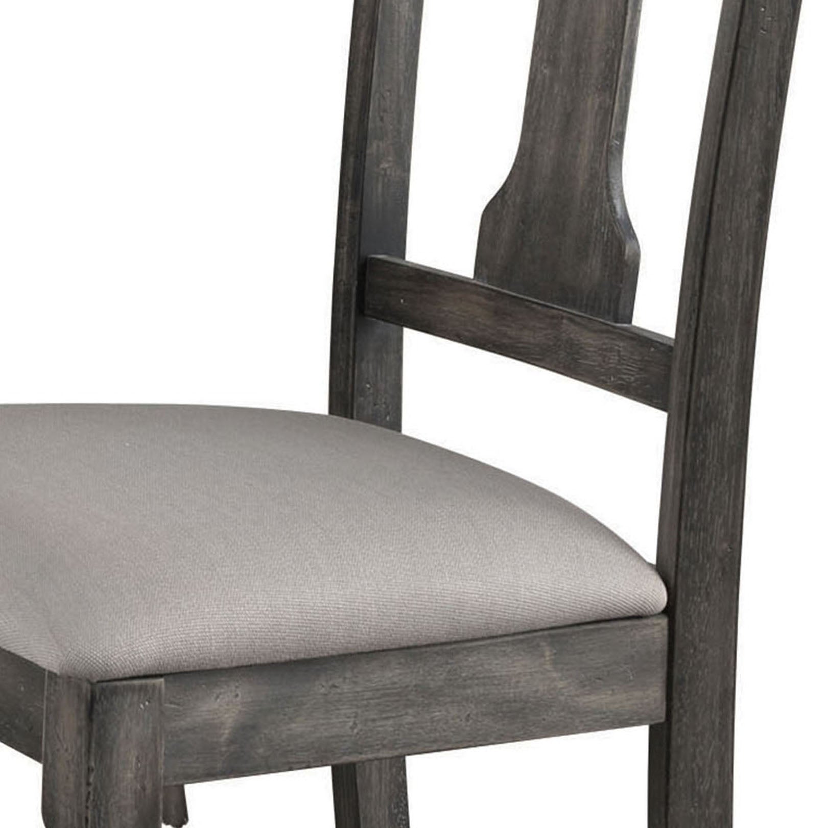 Closeup of upholstered seat on a distressed grey wood dining chair