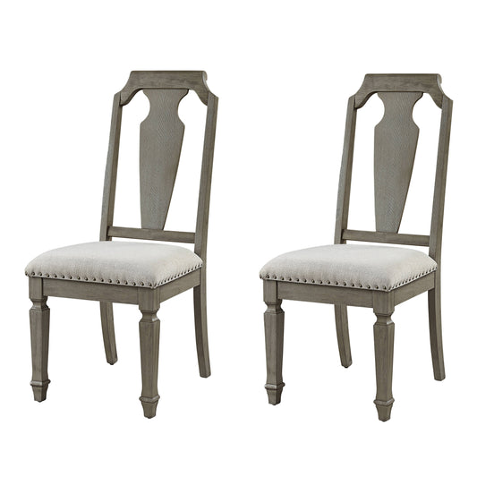 Two distressed gray wooden dining chairs with beige upholstered seats and nailhead trim