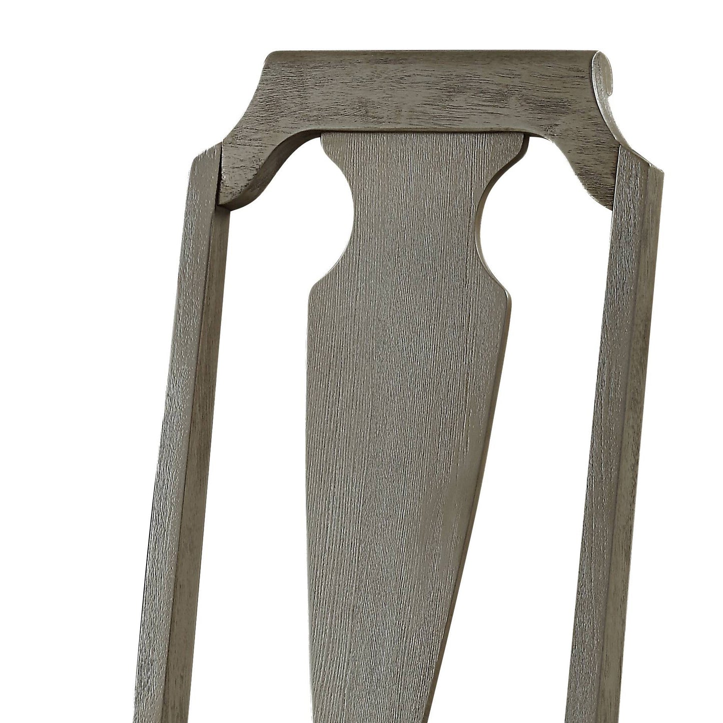 Closeup of carved grey wood dining chair back with rustic texture and elegant scroll detail