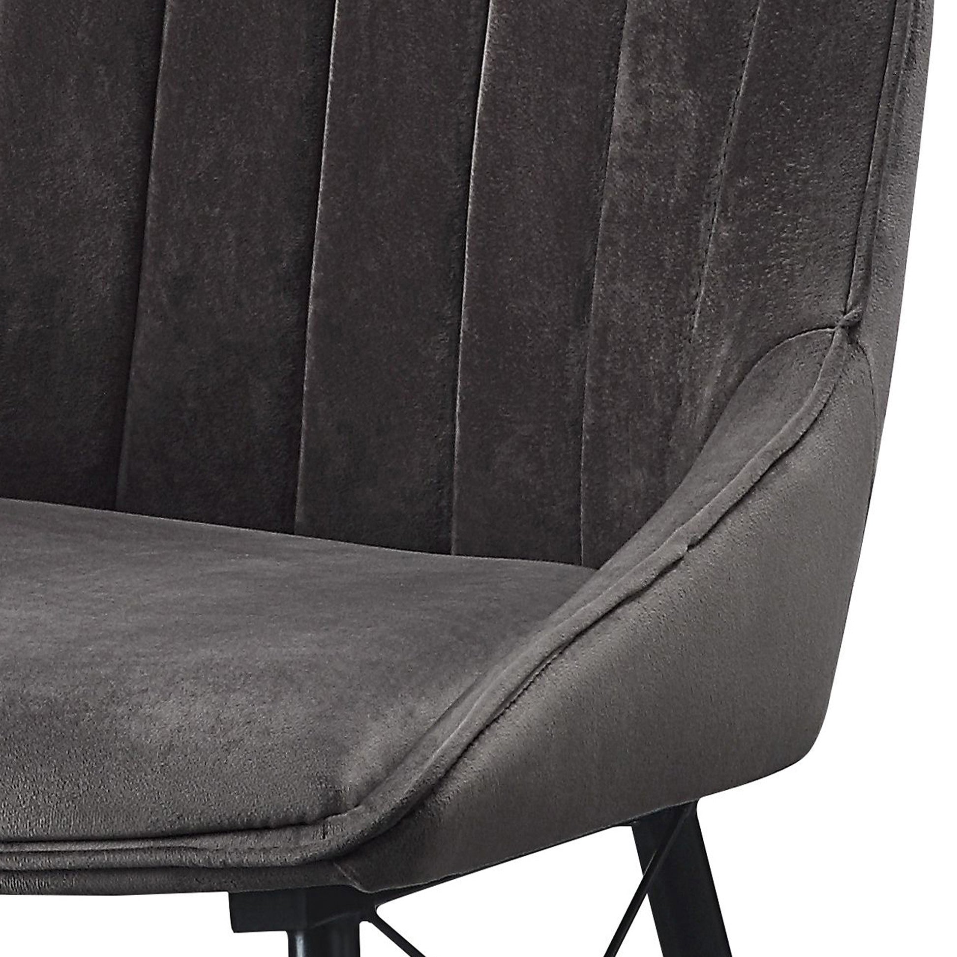 Close up of a dark gray upholstered dining chair with vertical channel tufting