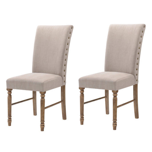 Pair of beige linen dining chairs with nailhead trim and turned wood legs