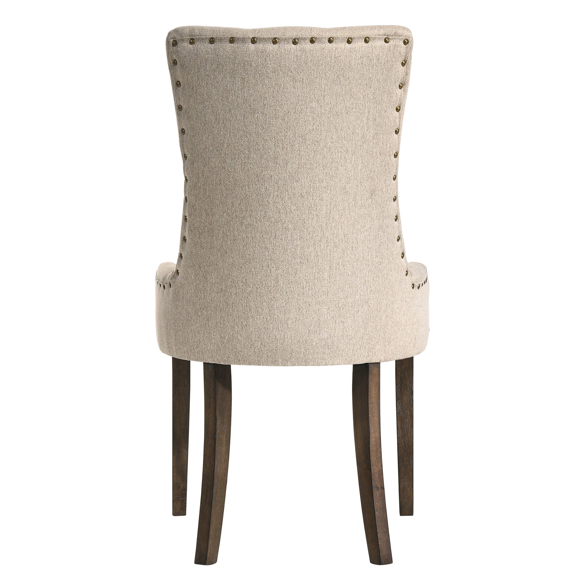 Back view of a beige upholstered dining chair with brass nailhead trim and dark wood legs