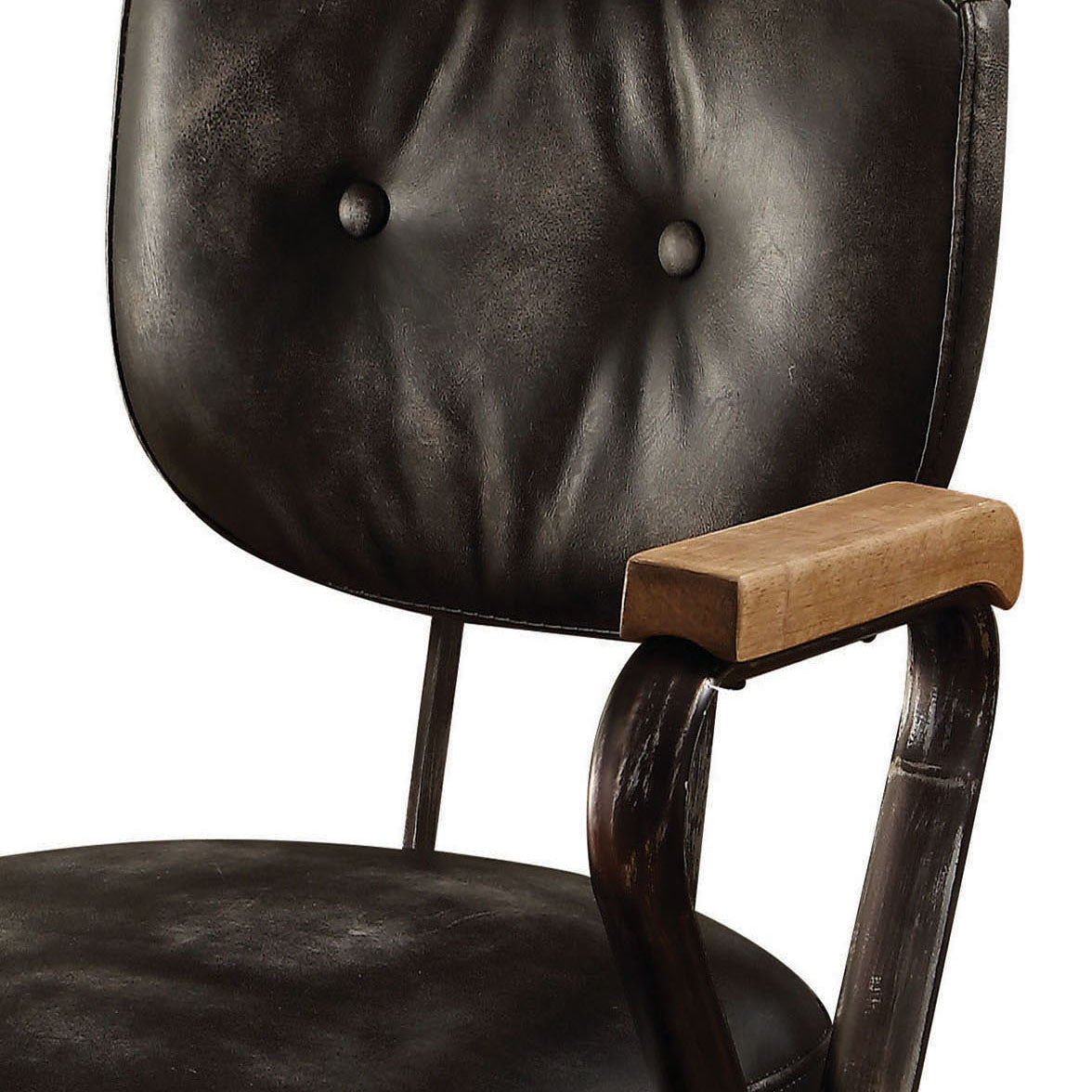 Tufted black leather office chair with distressed metal arms and a light wood armrest