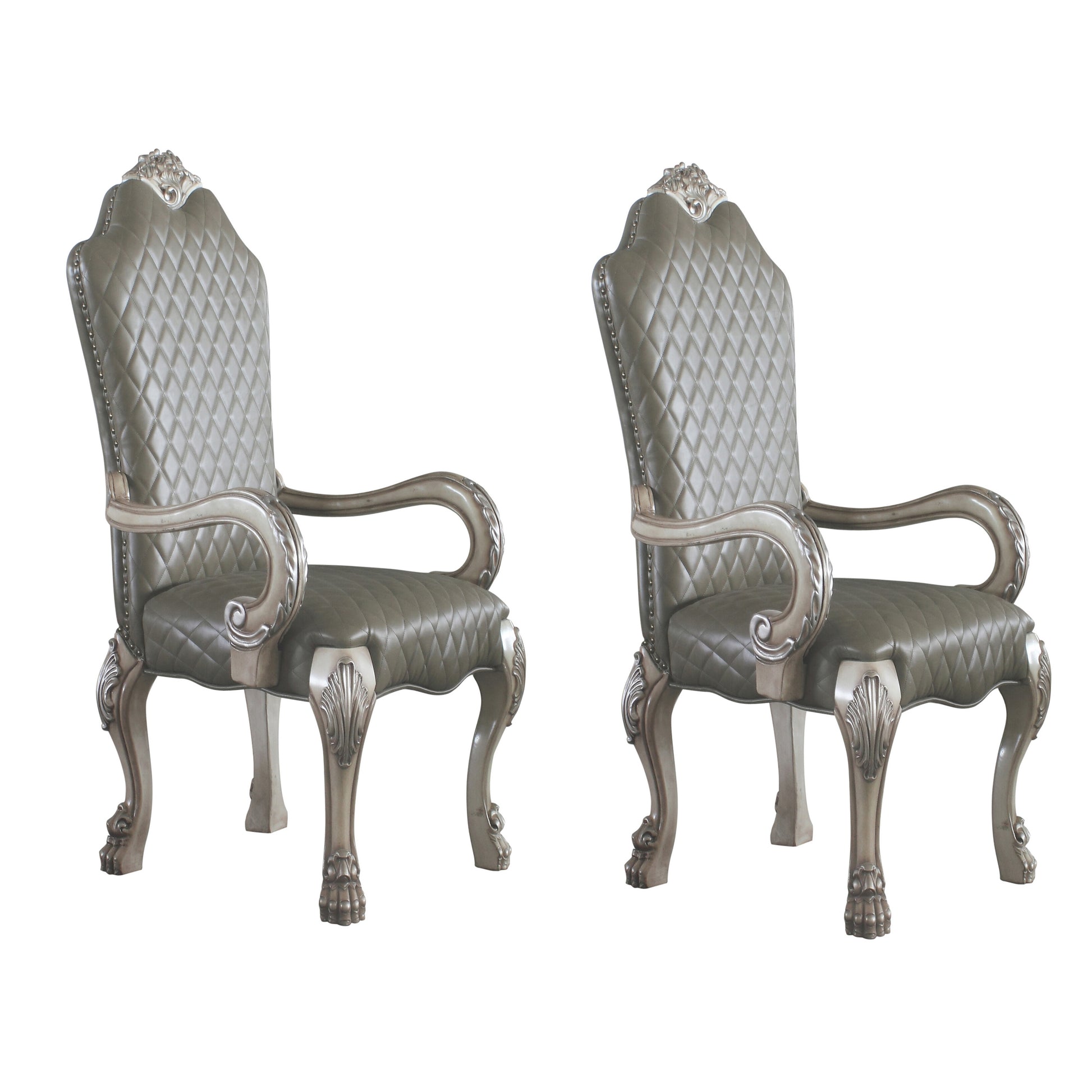 Two ornate tufted grey leather accent chairs with antique silver carved legs and arms