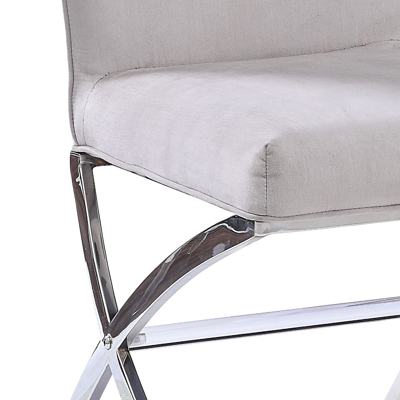 Close up of a silver chrome frame with a light grey upholstered seat on a modern accent chair