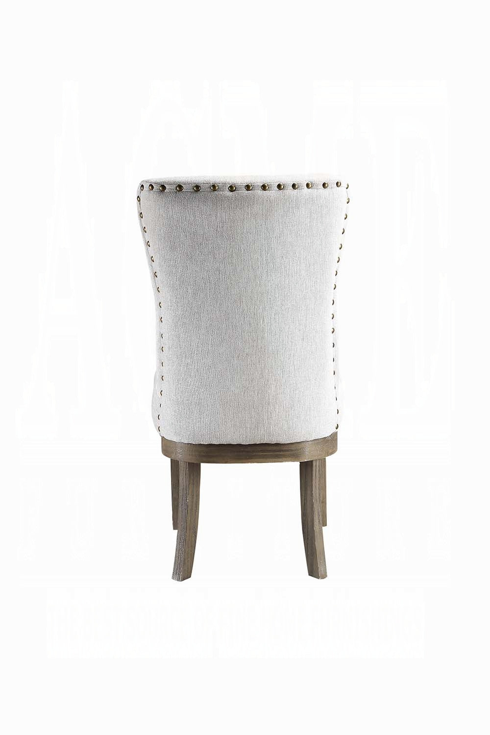 Elegant gray linen tufted accent chair with brass nailhead trim and distressed wood legs