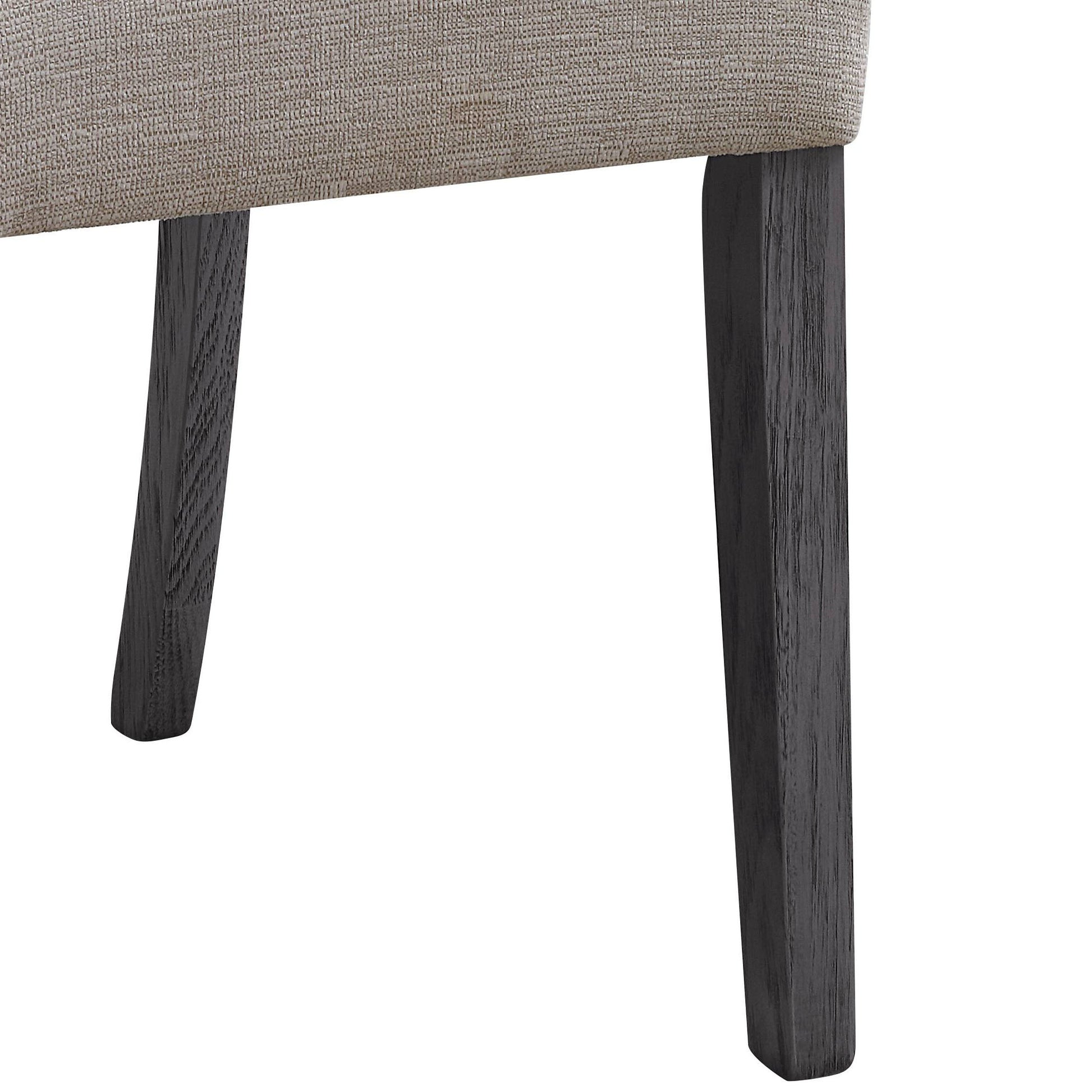 Closeup of a textured beige upholstered chair leg with dark oak wood finish