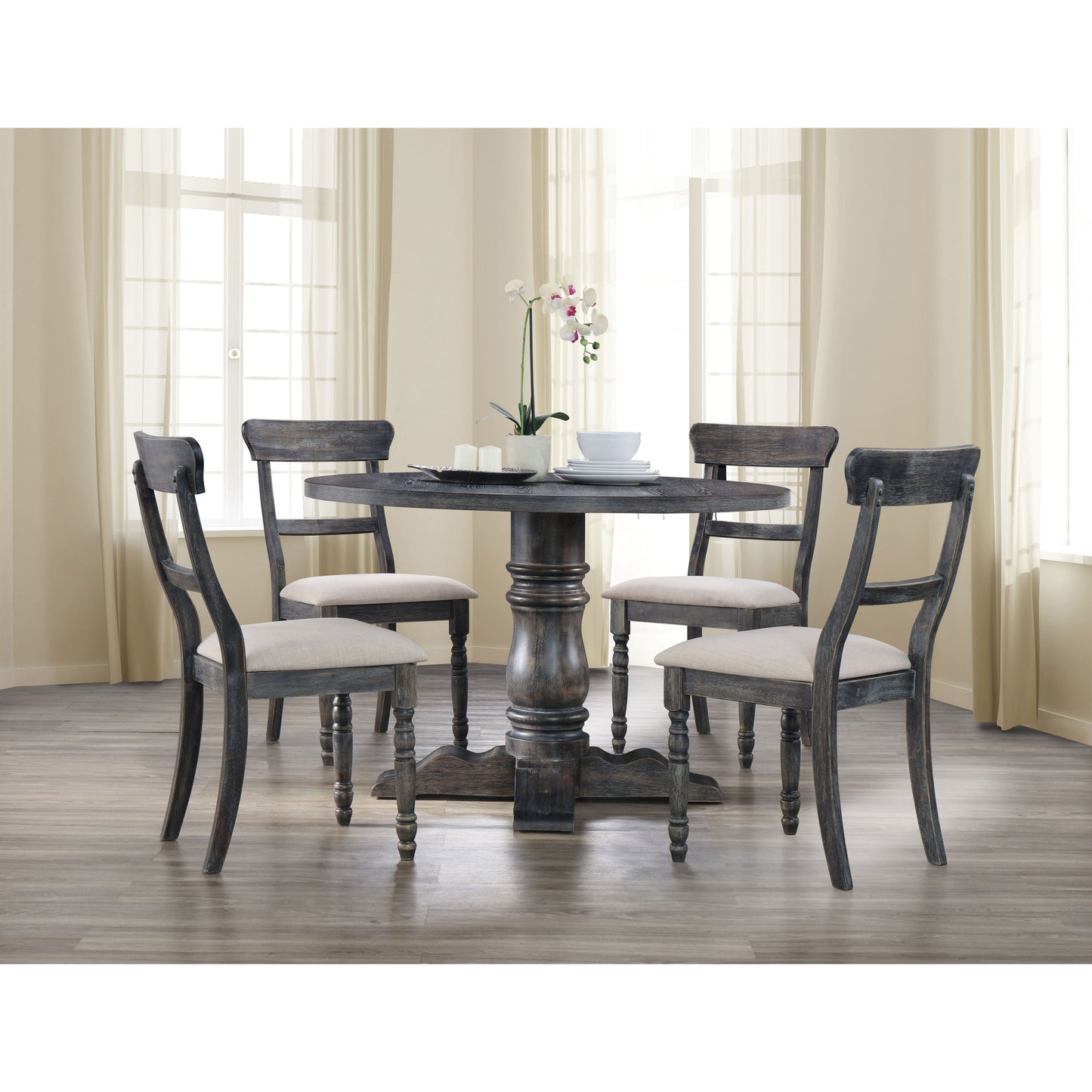 Dark distressed wood round dining table with four upholstered chairs