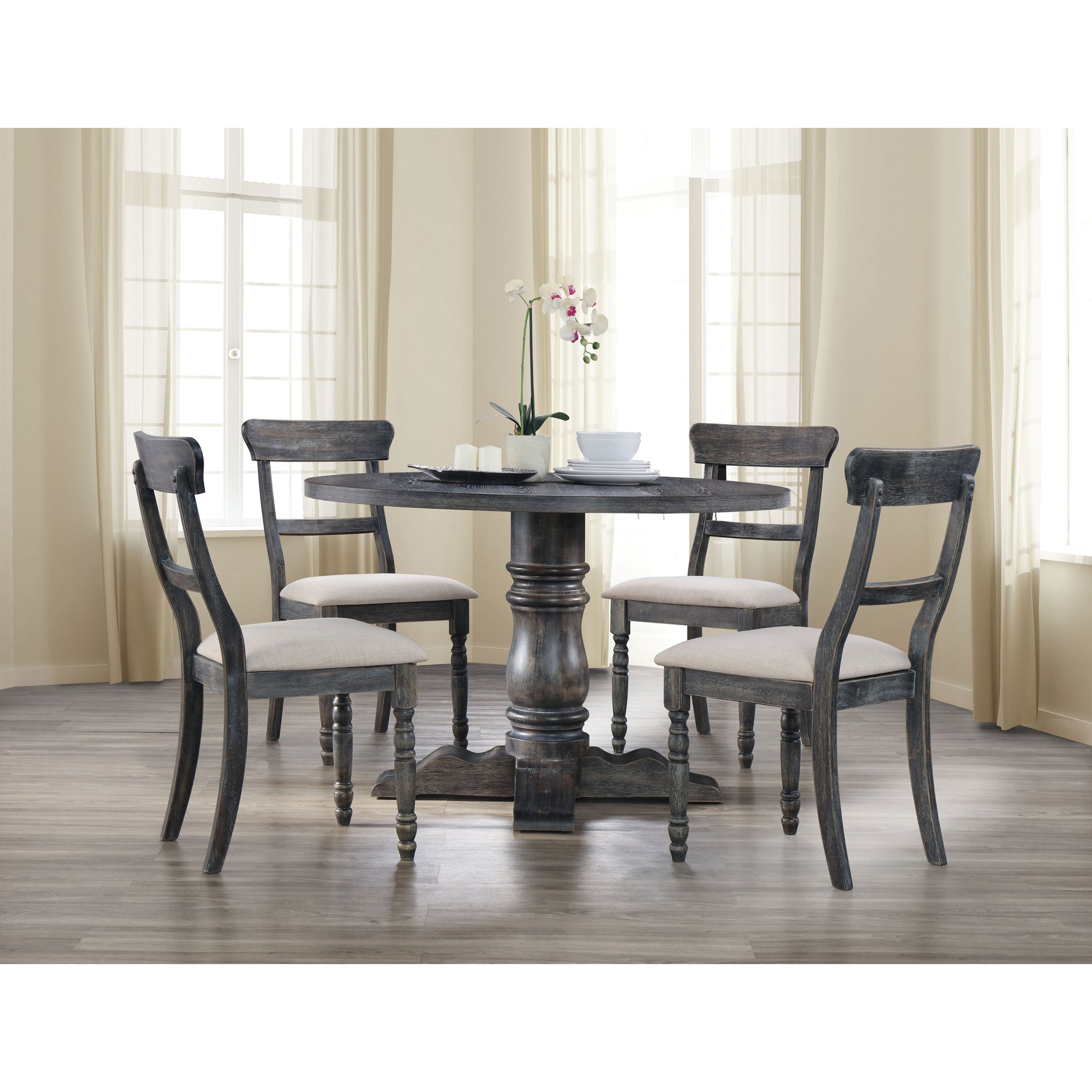 Dark distressed wood round dining table with four upholstered chairs