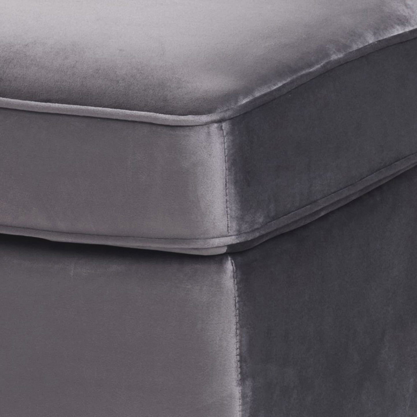 Closeup of a charcoal grey velvet ottoman with clean stitching detail