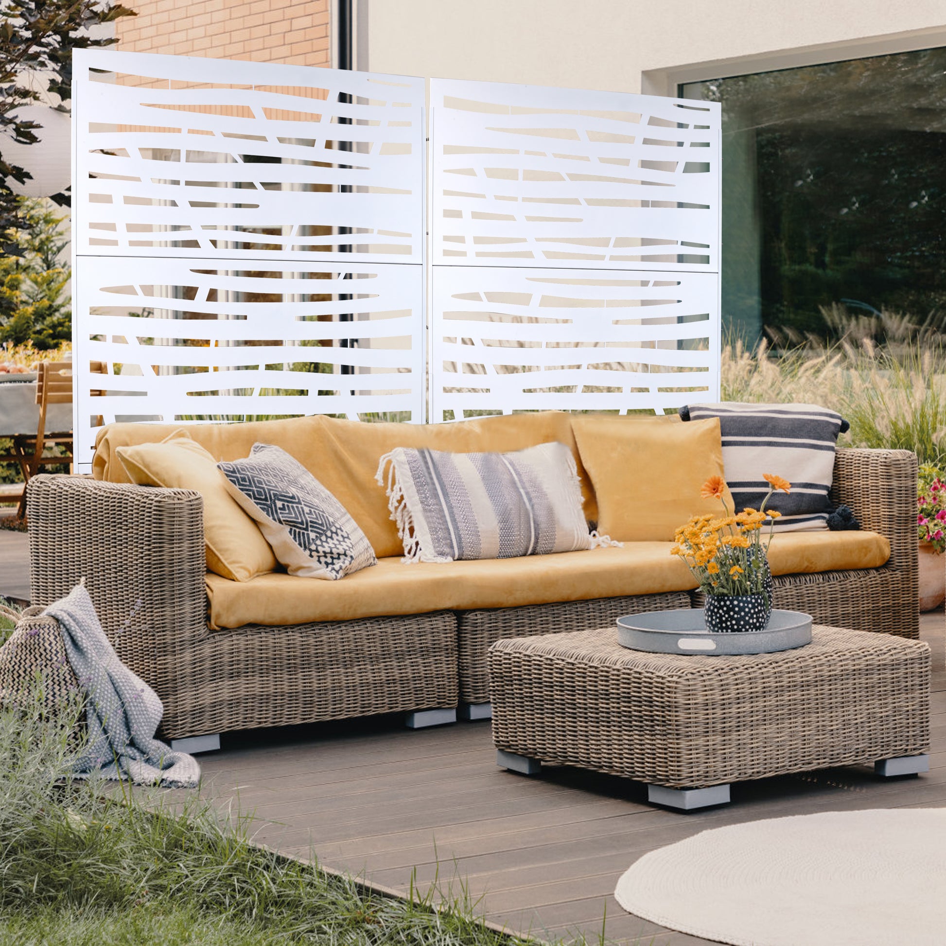 Wicker outdoor sofa with mustard yellow cushions and patterned pillows for a patio setting