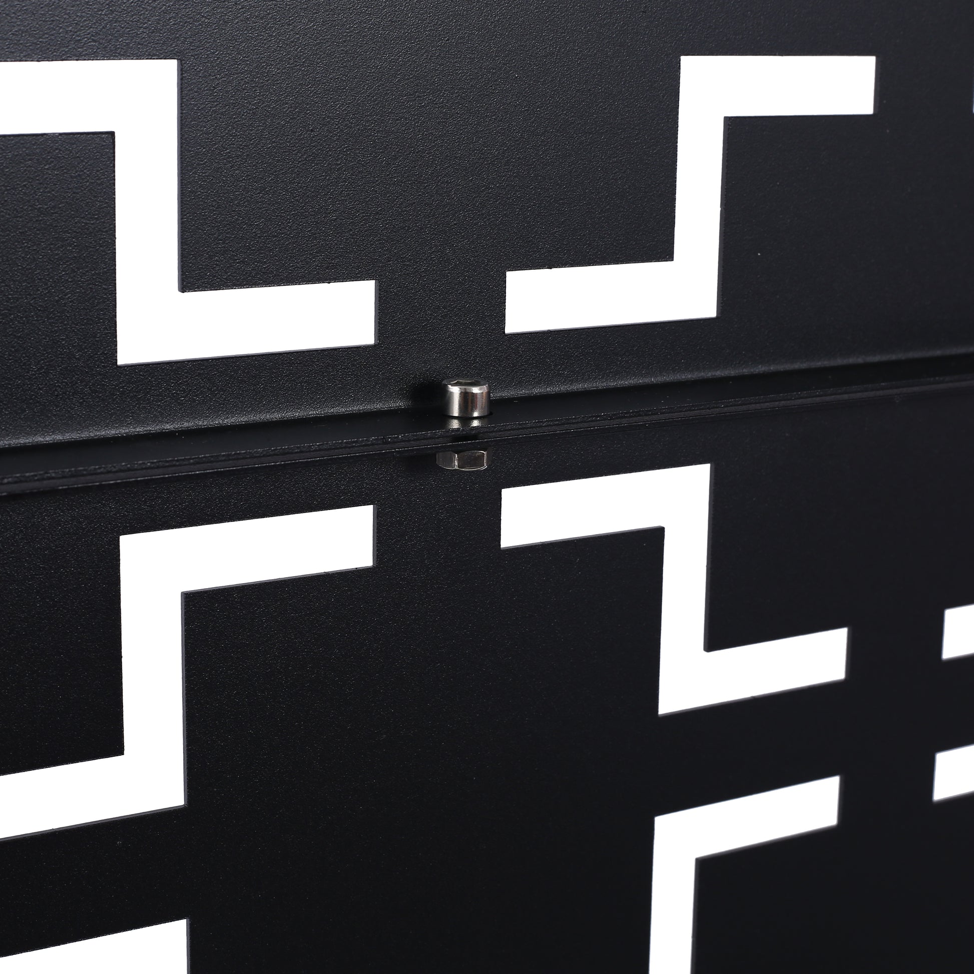 Black metal side table with white geometric cutouts and visible screw detail