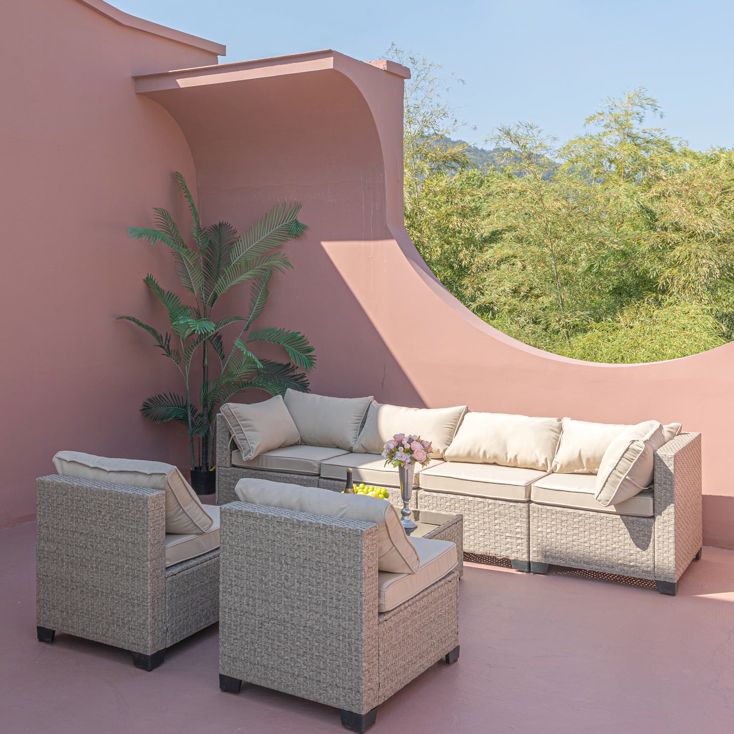 Wicker patio furniture set with beige cushions and accent pillows for outdoor seating