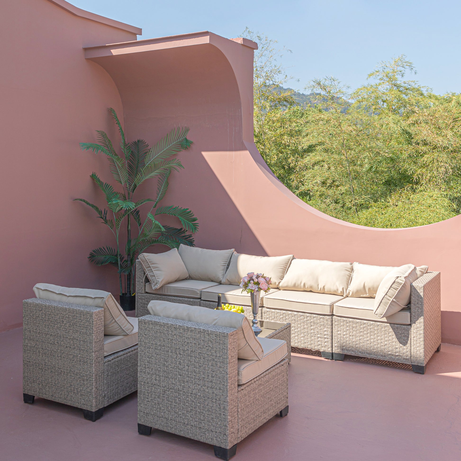 Wicker patio furniture set with beige cushions and accent pillows for outdoor seating