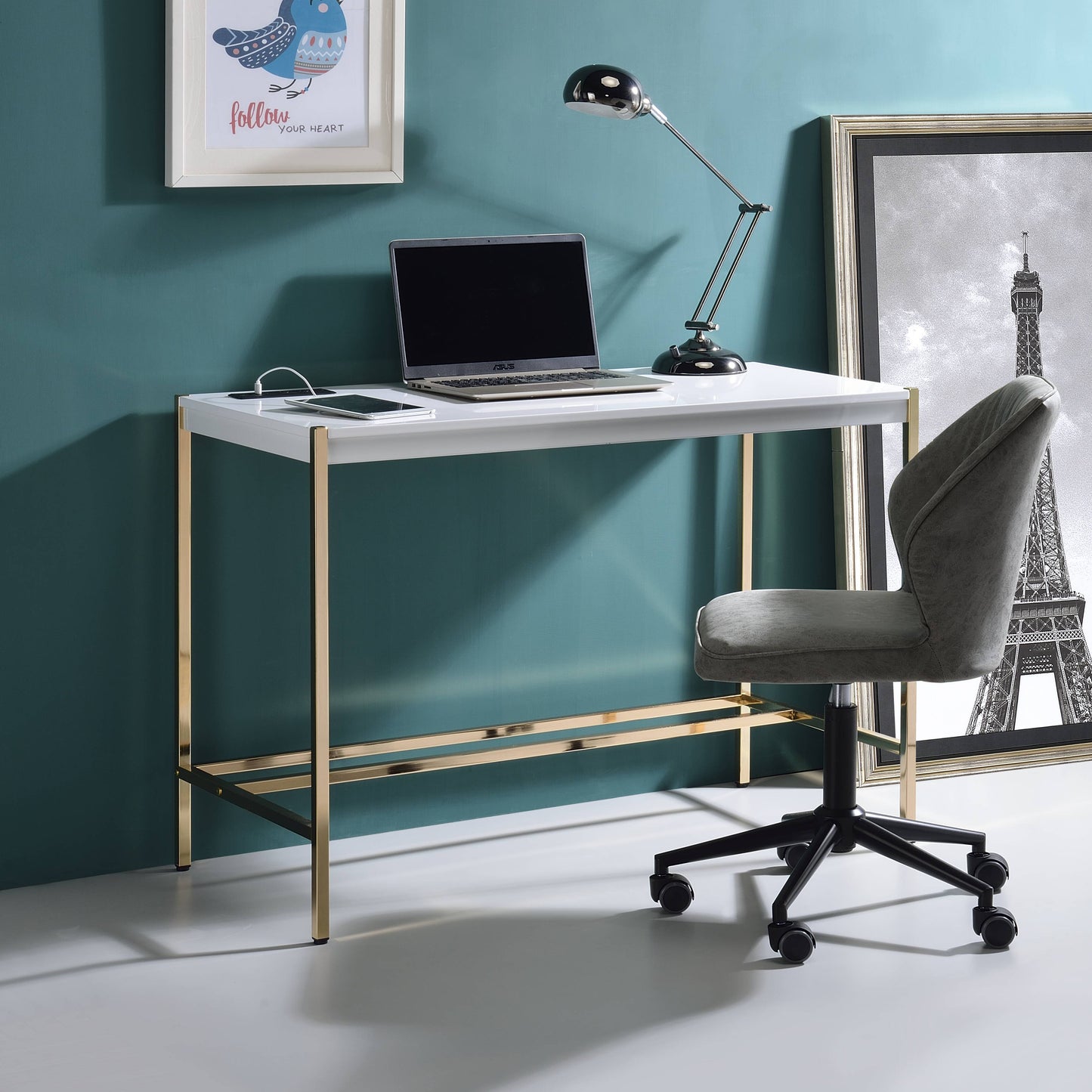 Sleek white desk with gold metal frame laptop and phone charging