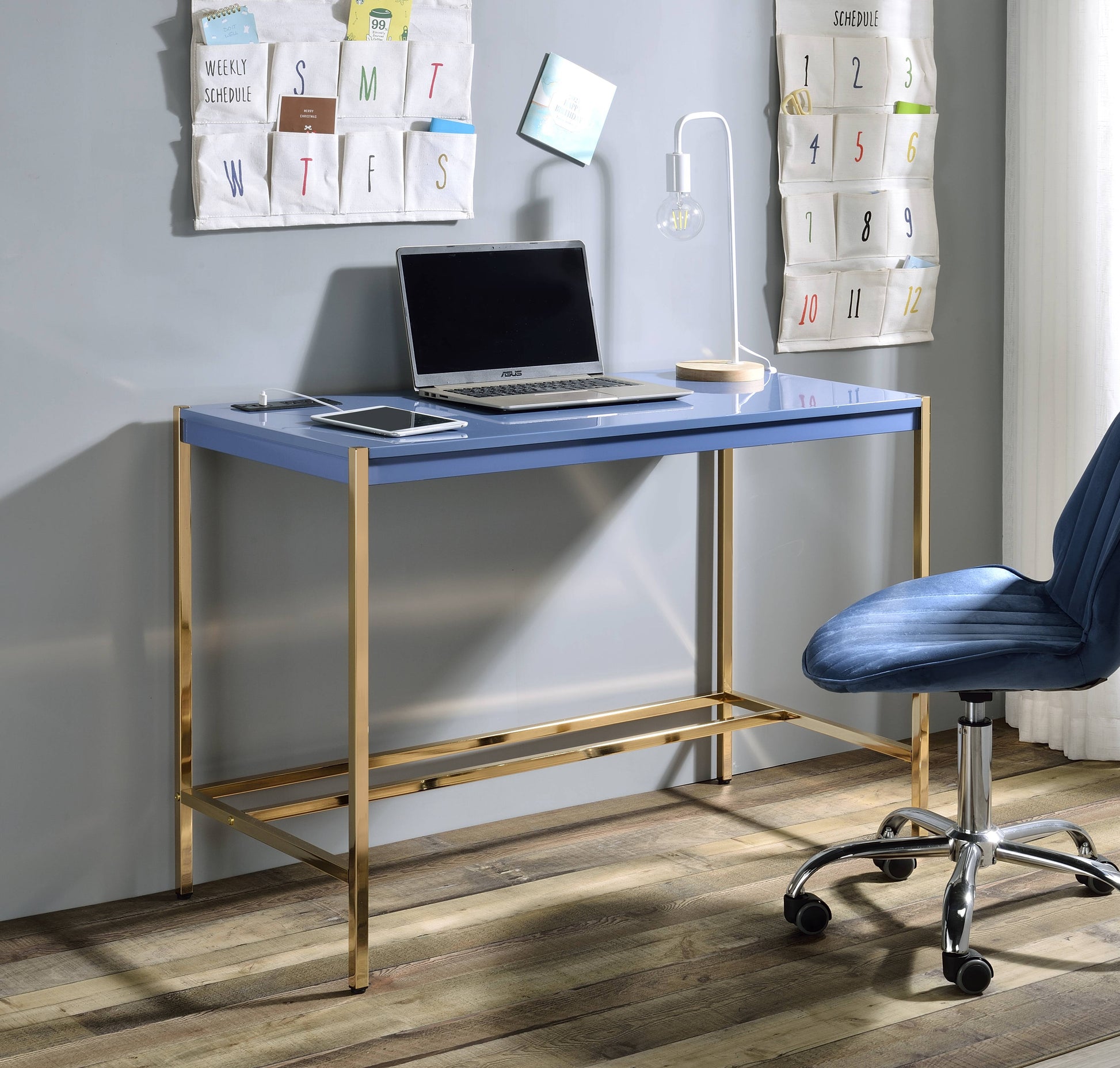 Blue executive desk with gold legs and a laptop and tablet setup