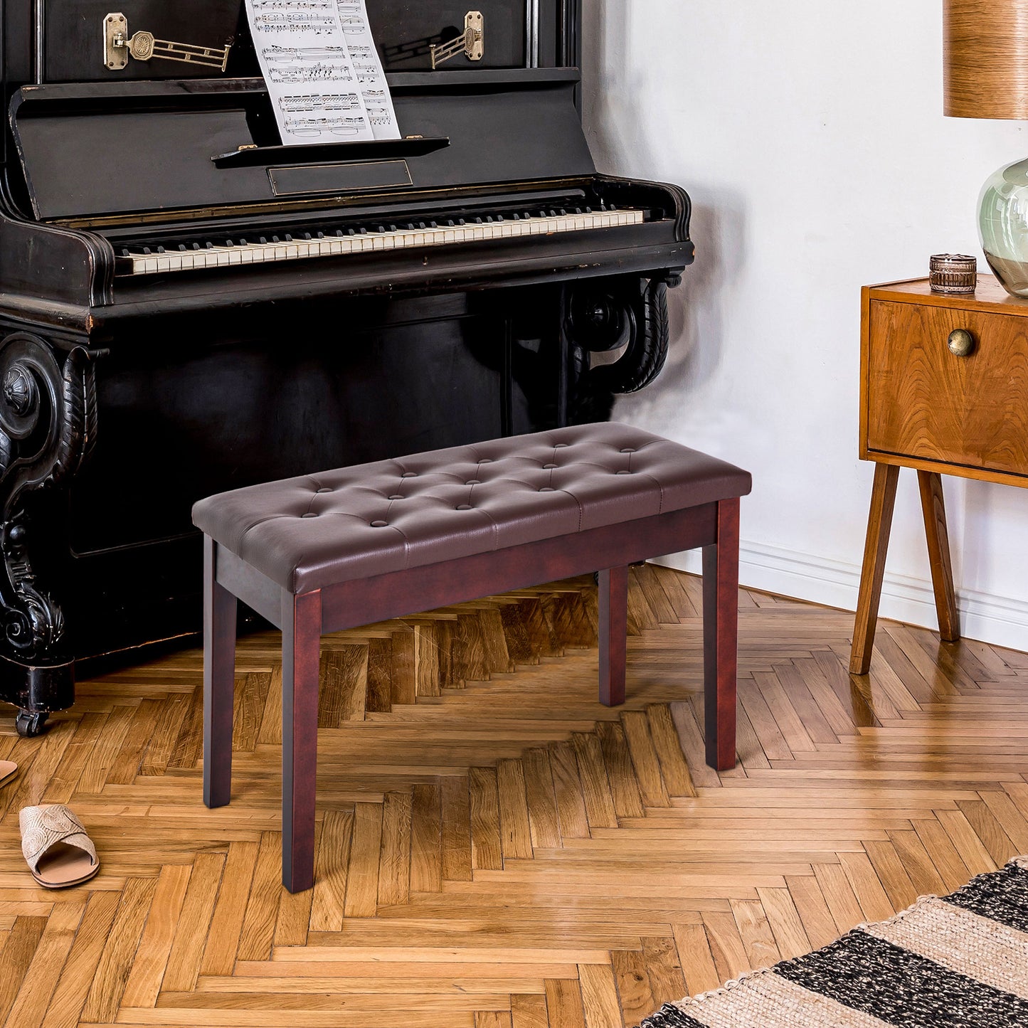 Tufted brown leather piano bench with dark wood legs