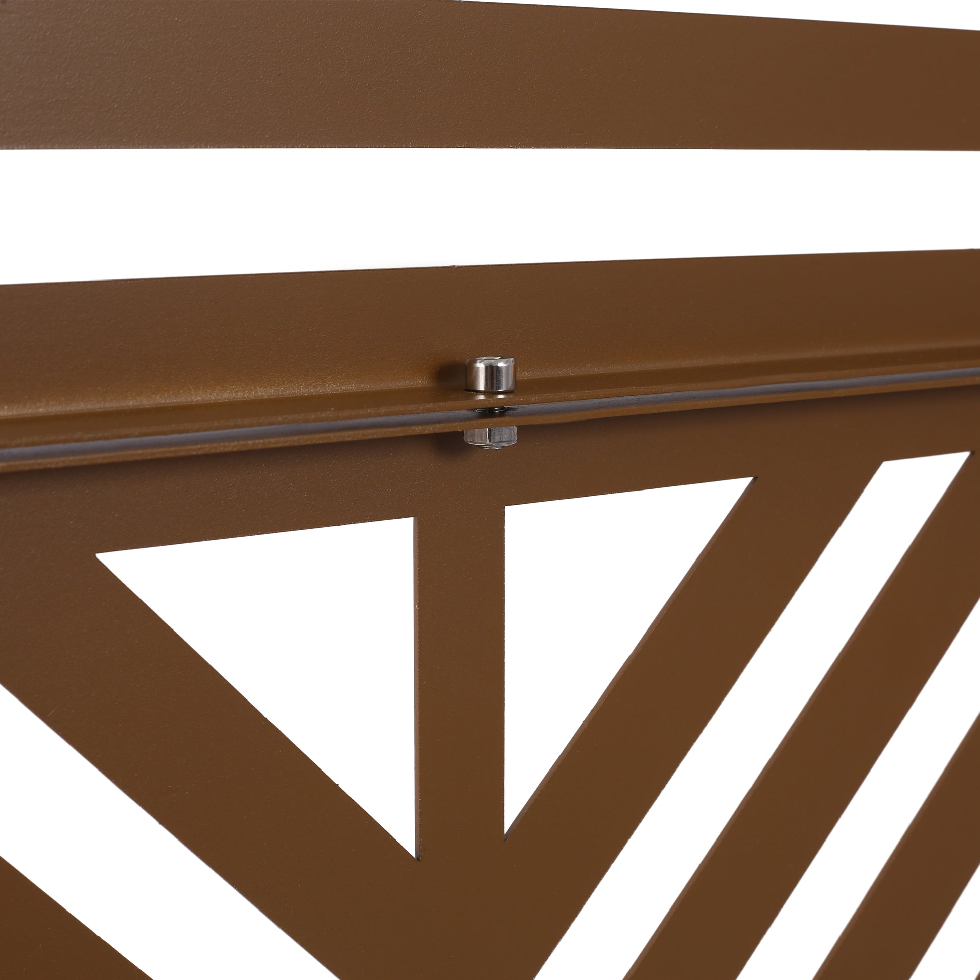 Closeup of a bronze metal fence panel with a geometric cutout design and visible bolt fastening