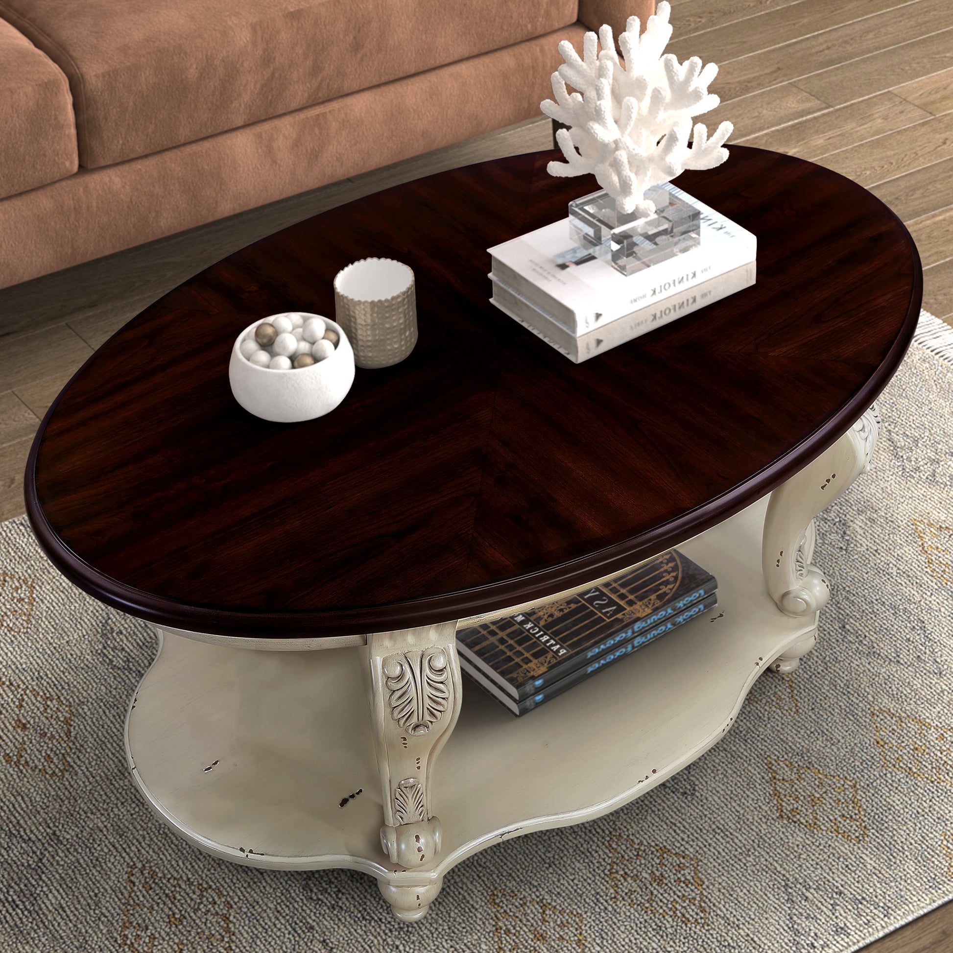 Dark wood oval coffee table with distressed cream pedestal base and carved details