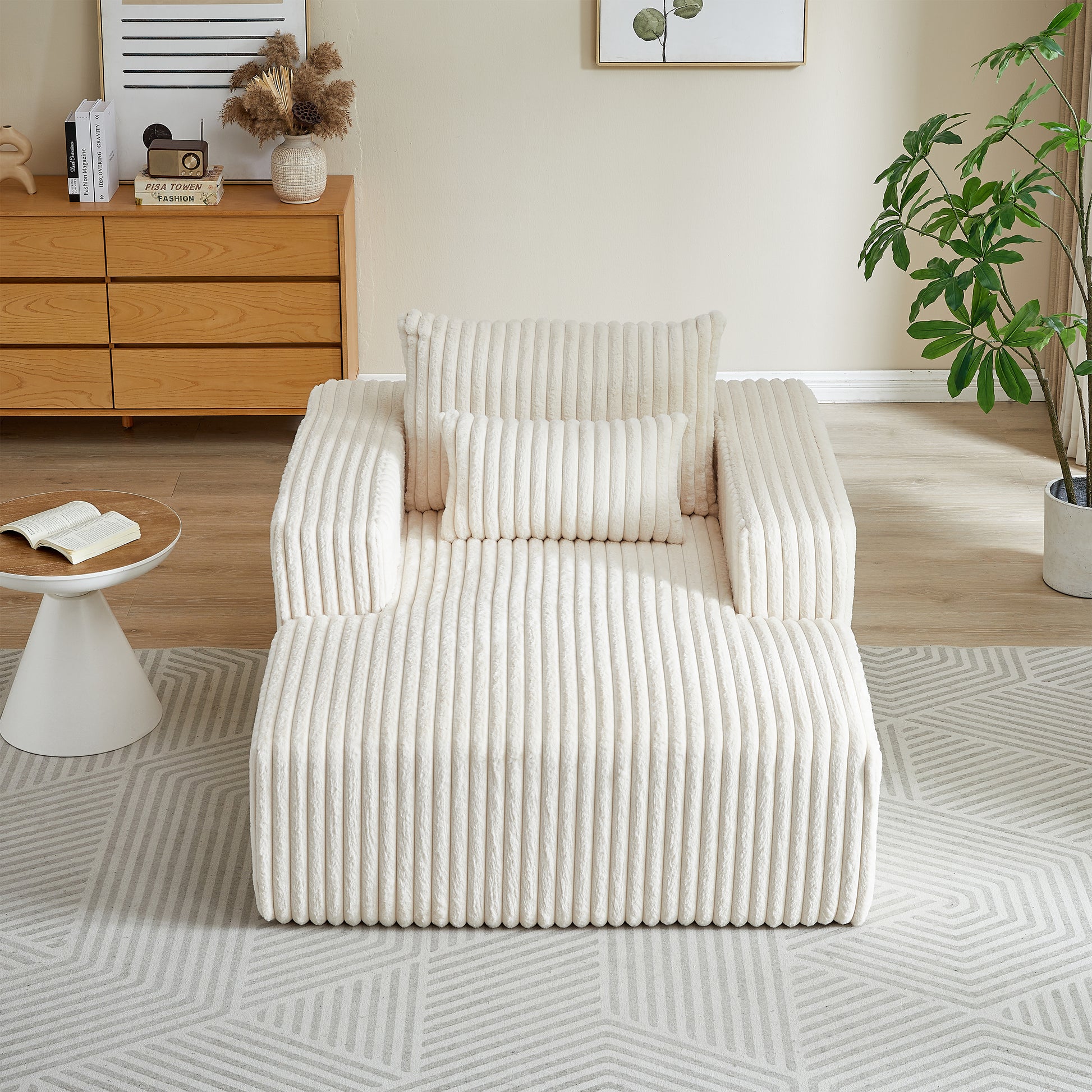 Cream corduroy accent chair with plush pillows on a geometric rug