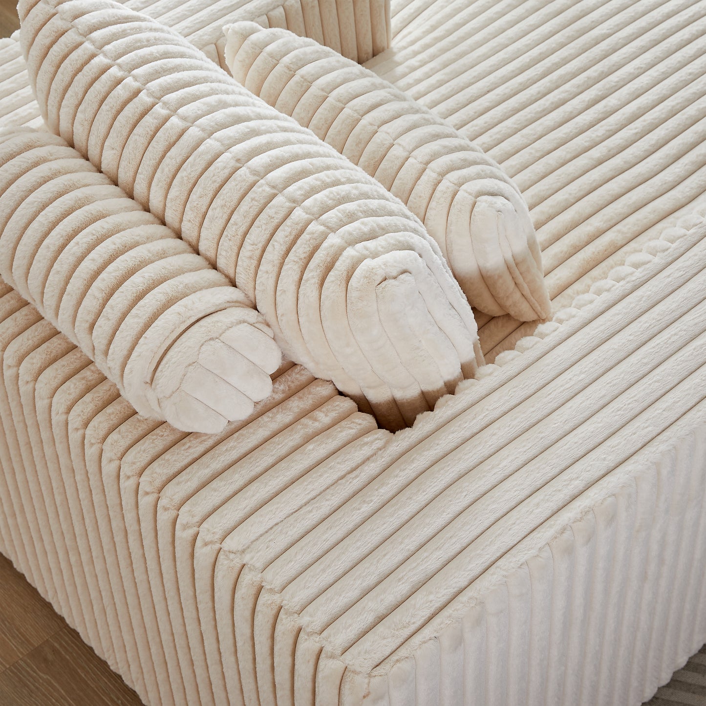 Plush cream corduroy sofa with rolled armrest cushions for comfort