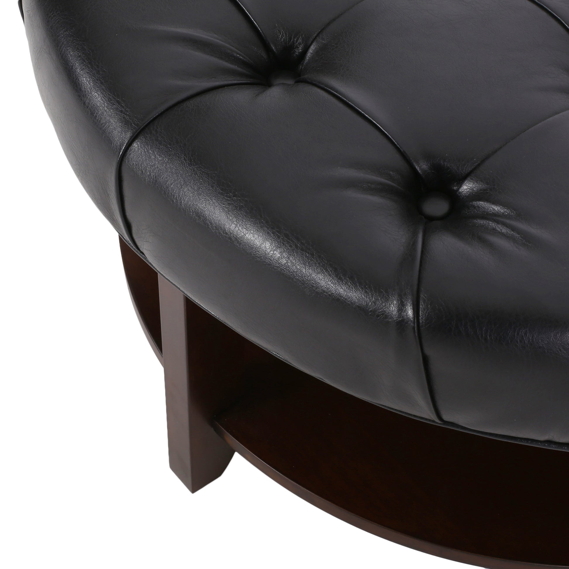 Closeup of tufted black faux leather upholstered ottoman