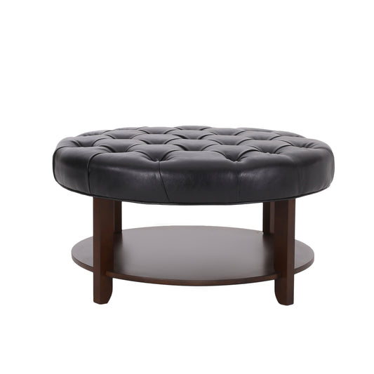 Black leather tufted round ottoman with dark wood base
