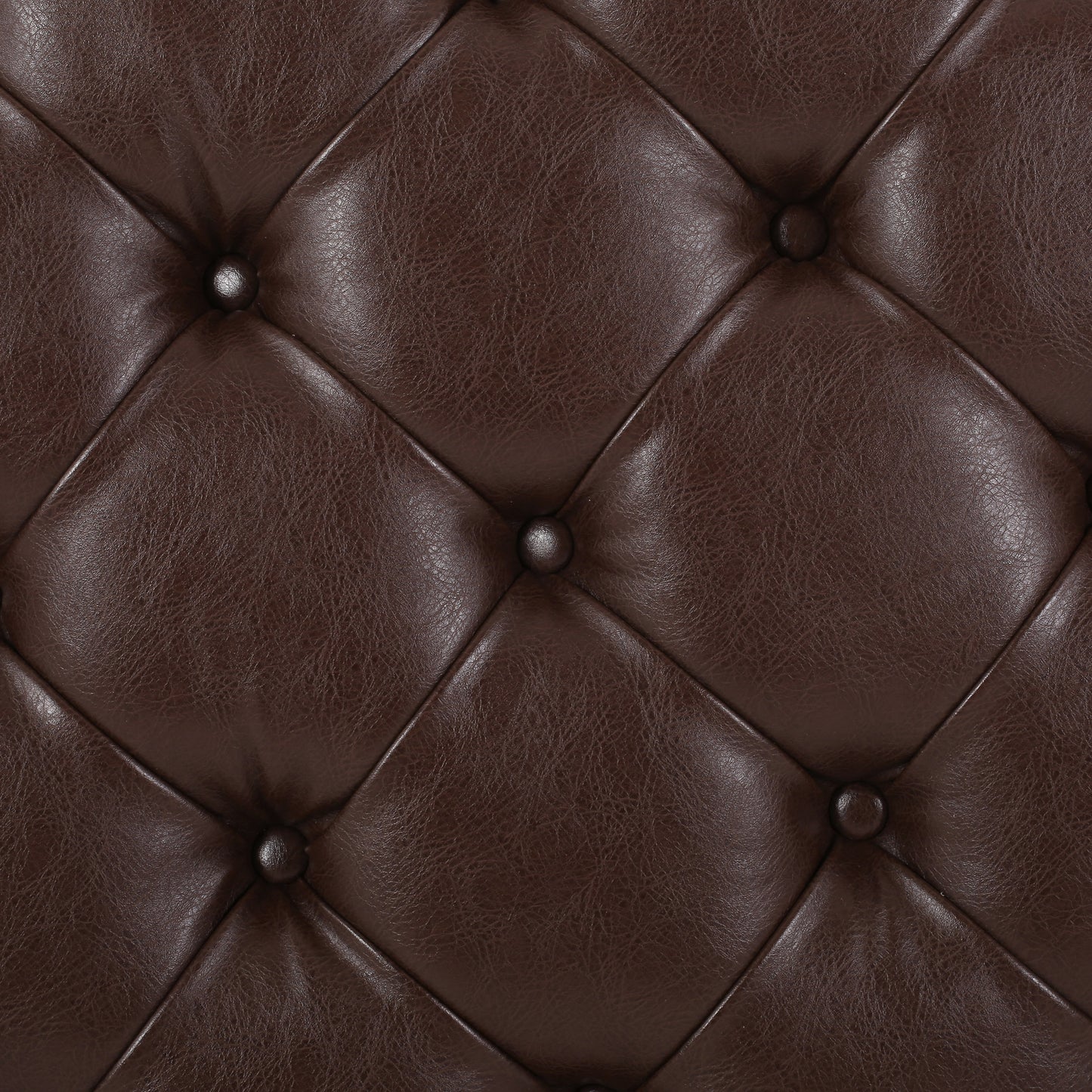 Closeup of dark brown tufted faux leather upholstery for furniture