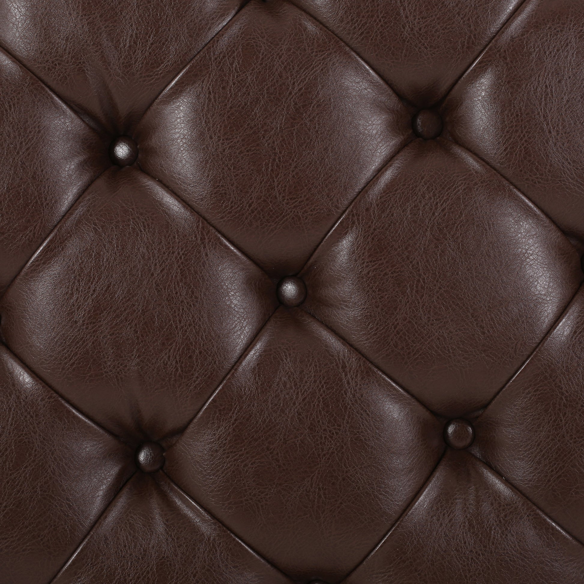 Closeup of dark brown tufted faux leather upholstery for furniture