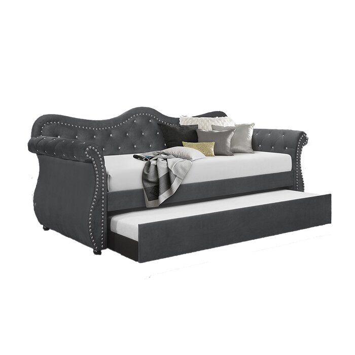 Dark gray velvet daybed with tufted back and studded trim features pullout trundle for guests