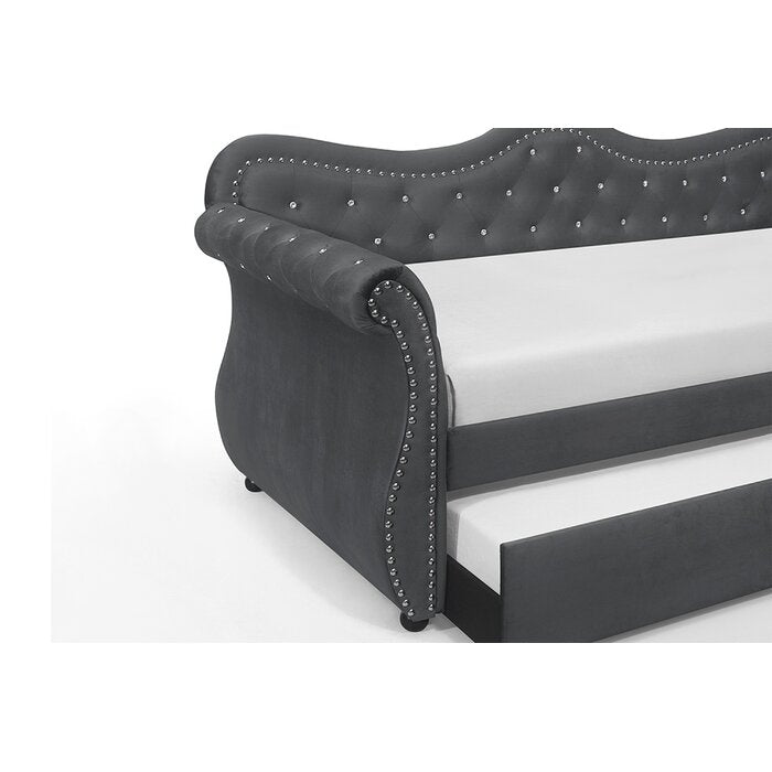 Dark grey velvet daybed with tufted back and silver nailhead trim featuring a pullout trundle bed
