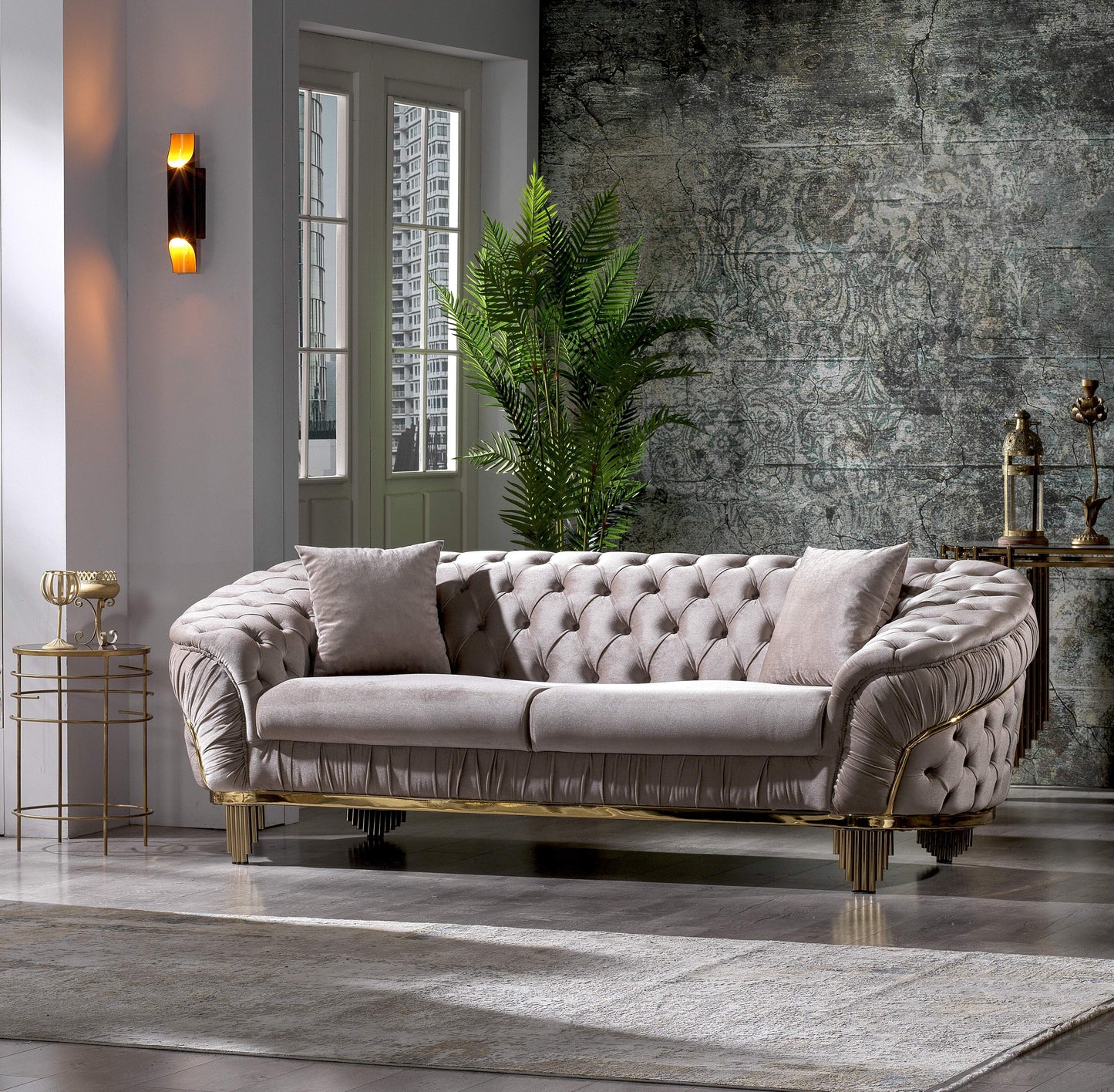 Tufted plush sofa in a light neutral tone with gold accents and decorative pillows