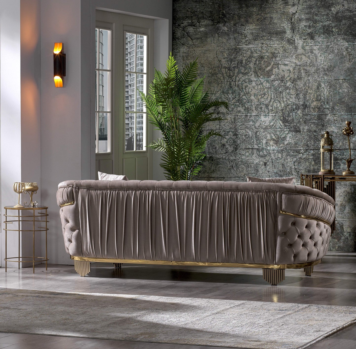 Luxurious taupe velvet sofa with tufted back and ornate gold accents