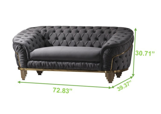 Dark gray velvet tufted loveseat with gold trim and fluted legs for a luxurious living room