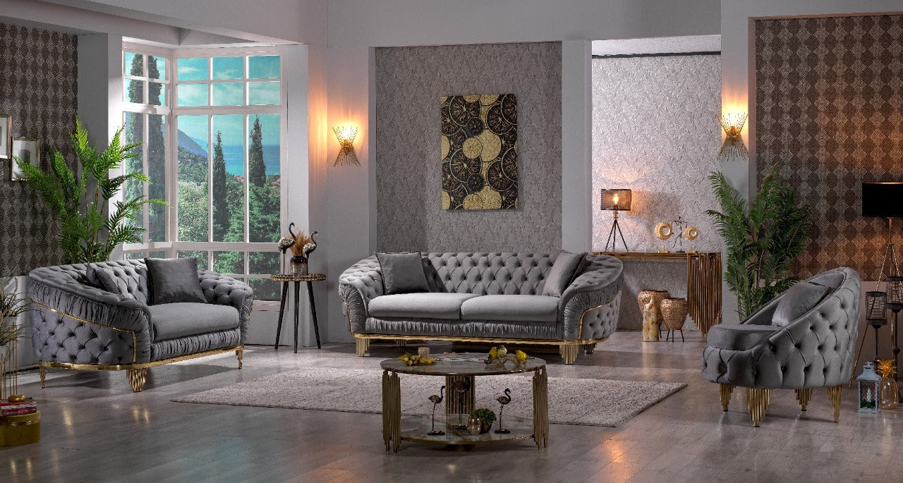 Grey velvet tufted sofa with gold trim and ornate legs perfect for a luxury living room