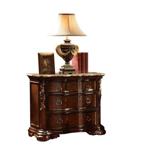Ornate mahogany nightstand with three drawers marble top and decorative lamp