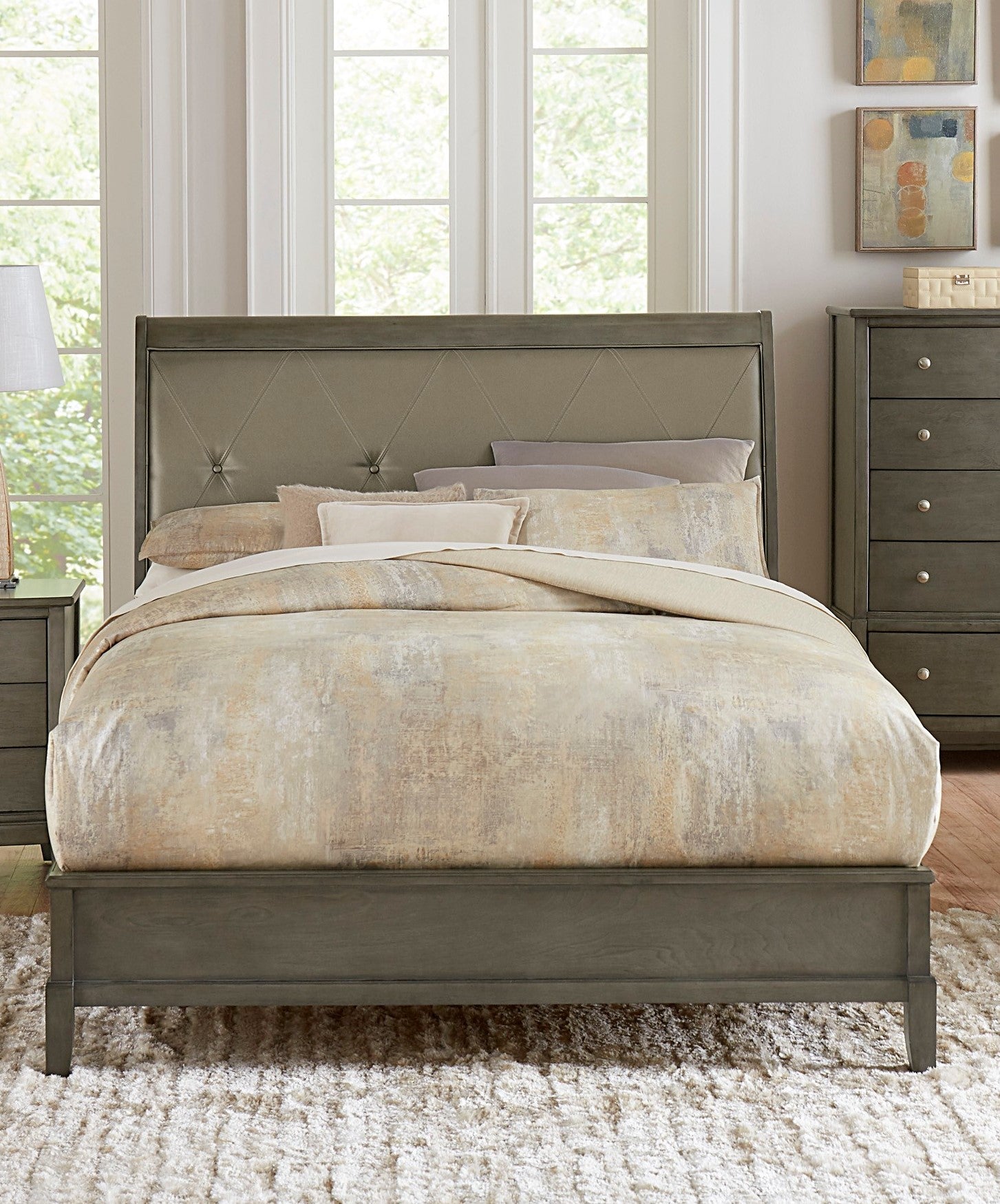 Gray upholstered diamondtufted headboard bed frame with neutral patterned comforter