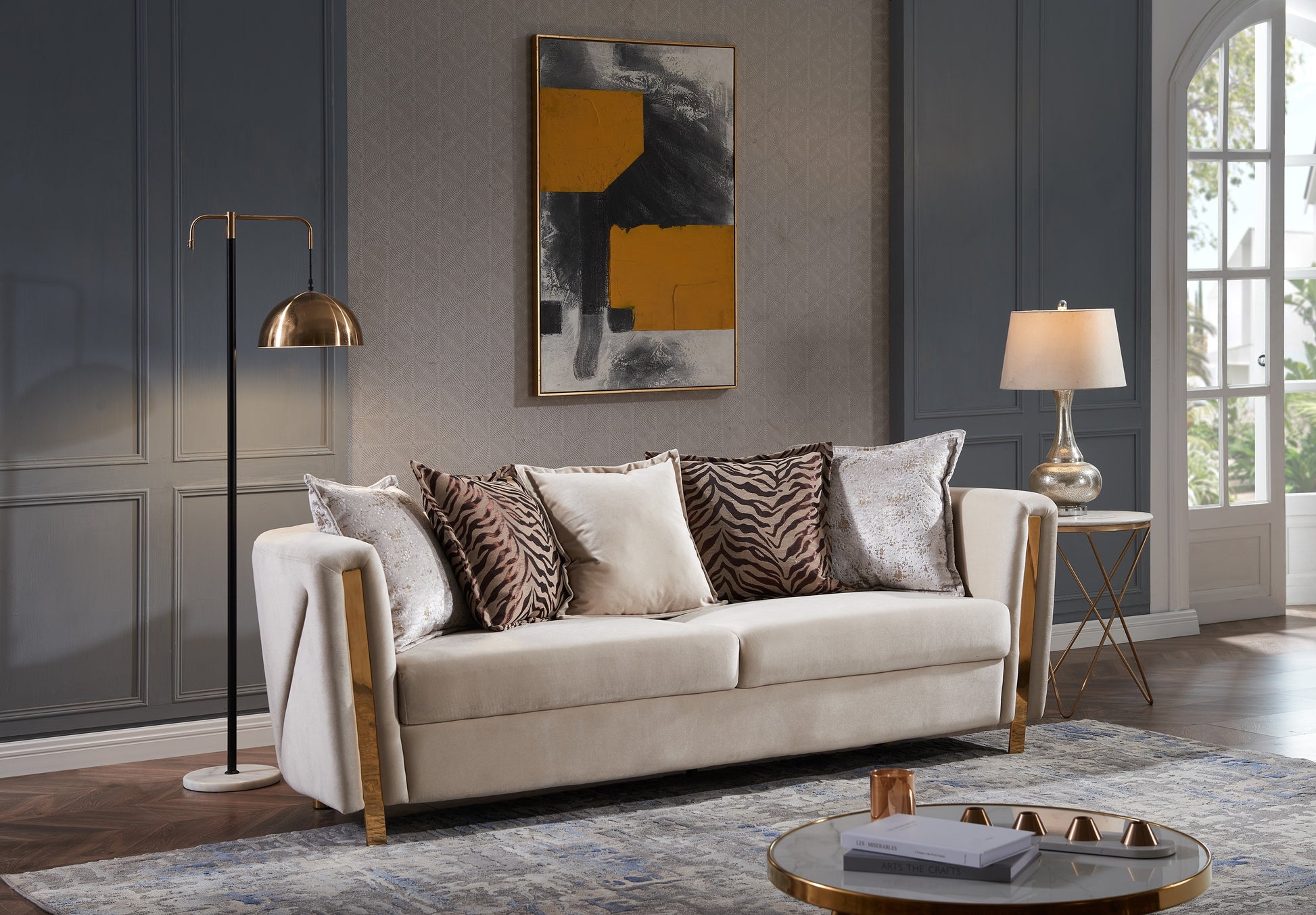 Cream velvet sofa with gold accents and decorative throw pillows