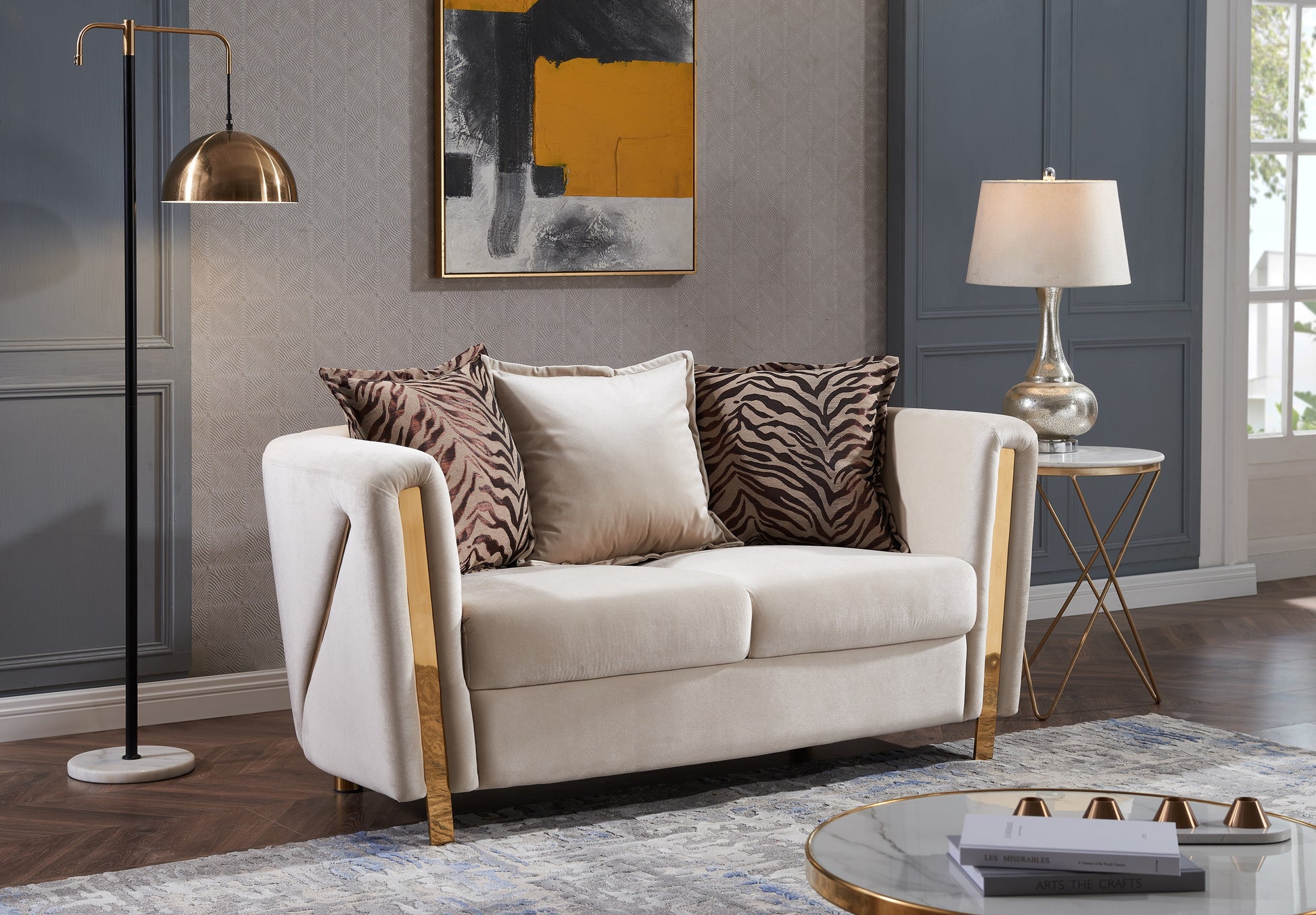 Plush beige velvet loveseat with gold trim and animal print accent pillows