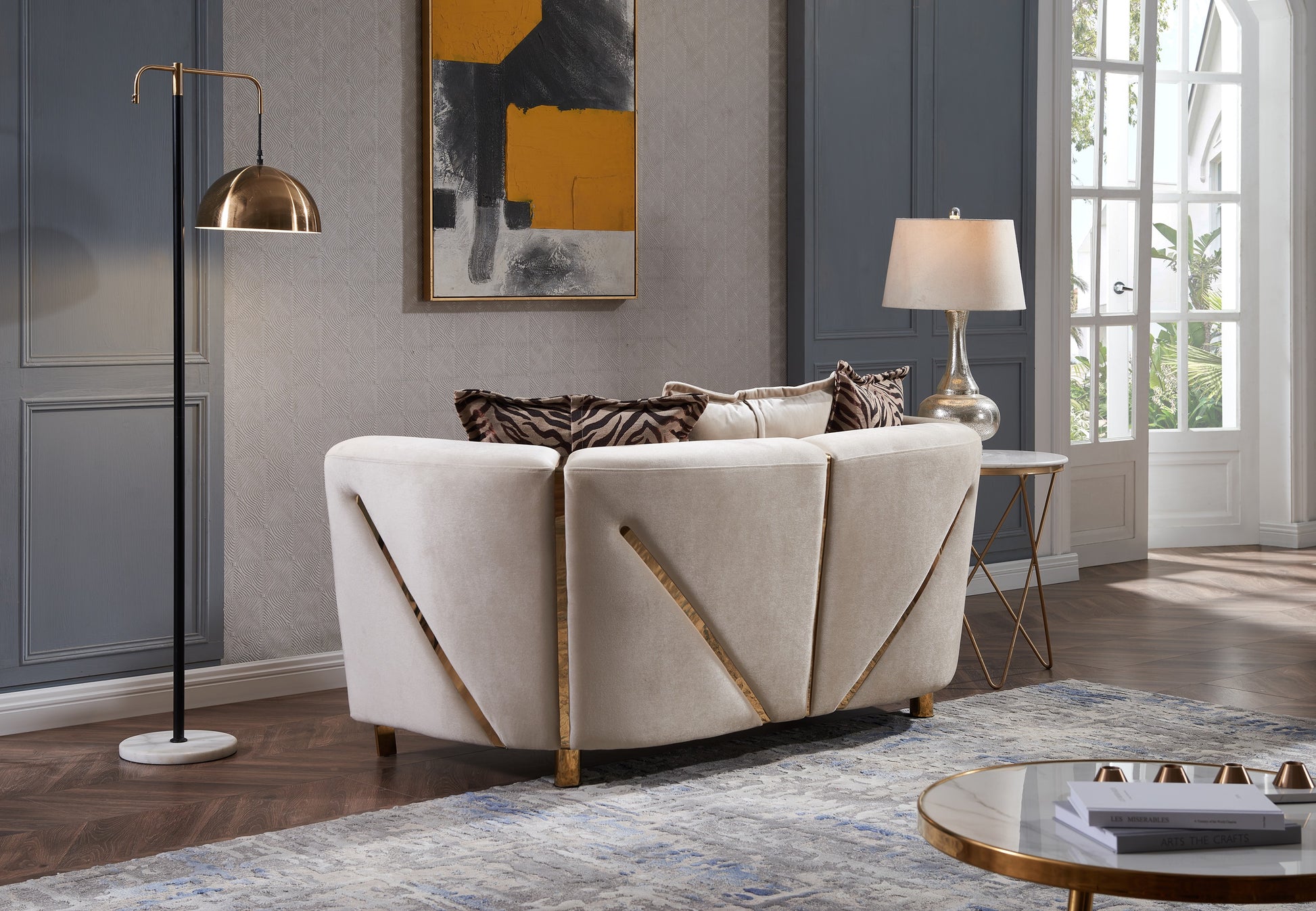 Plush beige velvet sofa with gold geometric accents and animal print pillows modern living room accent