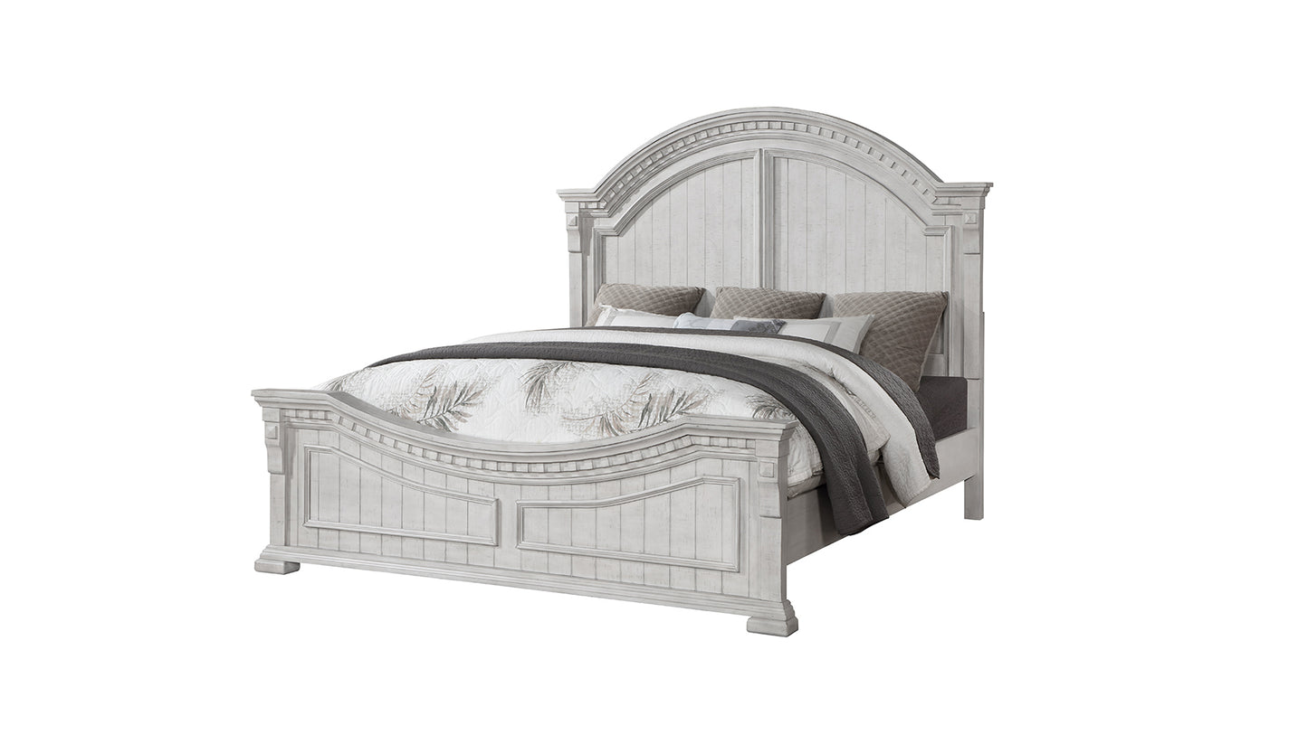 White distressed wooden king size bed with upholstered headboard and layered bedding